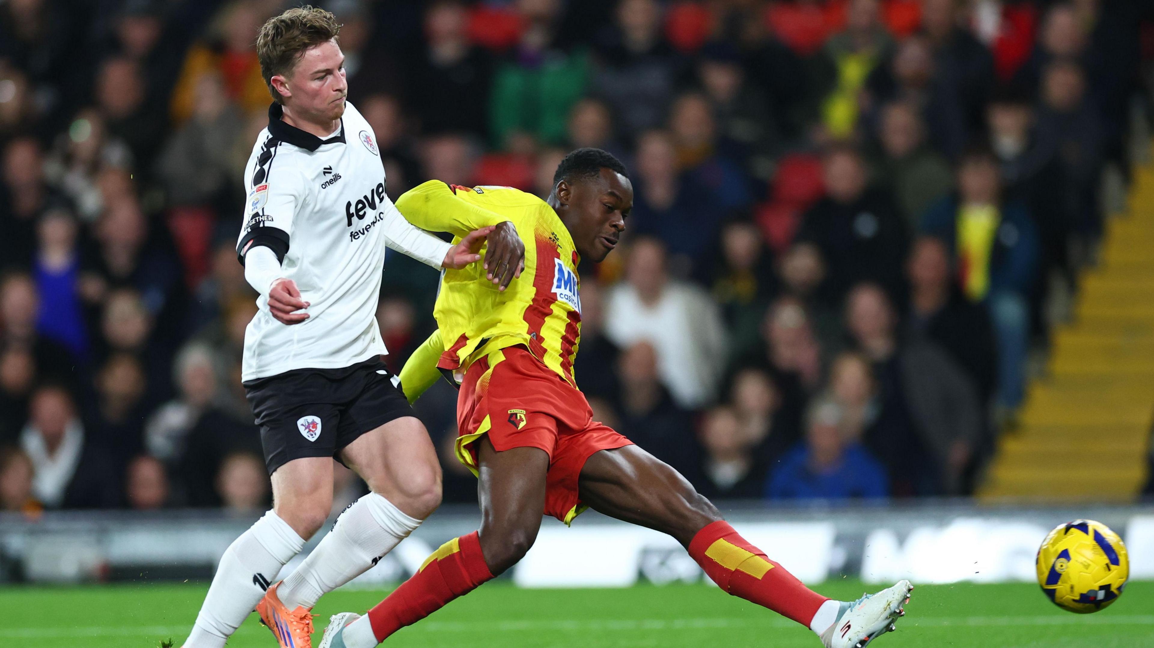 Watford's Marc Bola shooting and scoring under pressure from Bristol City defender George Tanner.