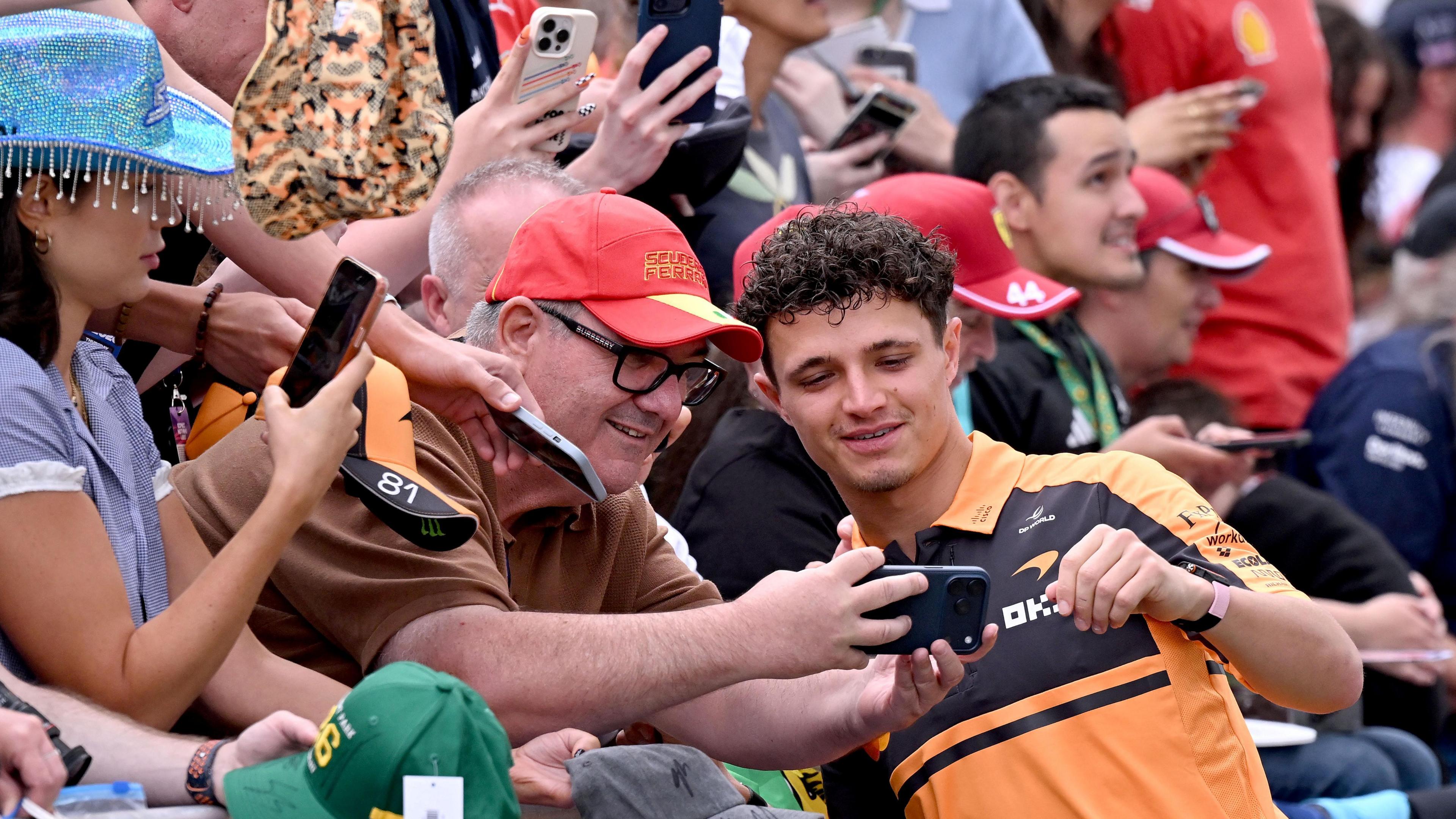 Lando Norris poses for a selfie with fans before first practice for the Australian Grand Prix