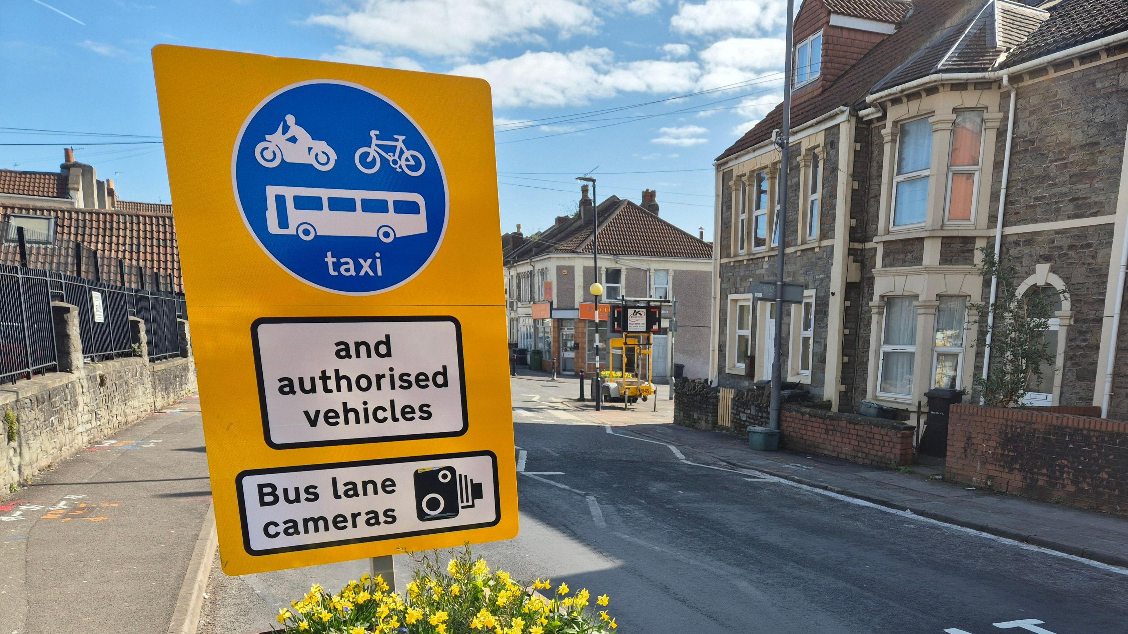 A bus gate installed as part of the liveable neighbourhood scheme. There is a yellow sign that shows only bikes, buses and taxis are allowed down the road.