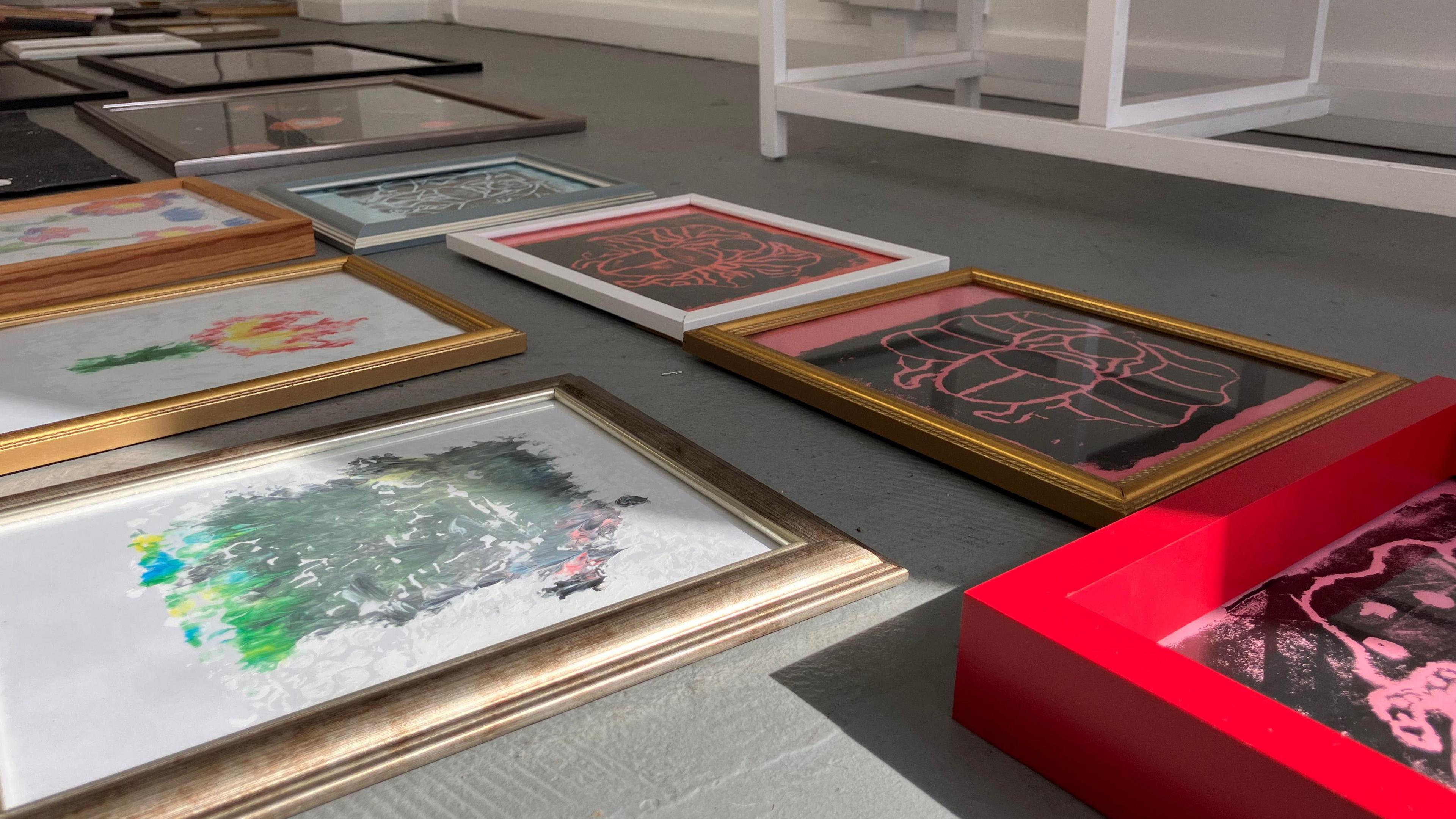 Framed pictures on a floor.