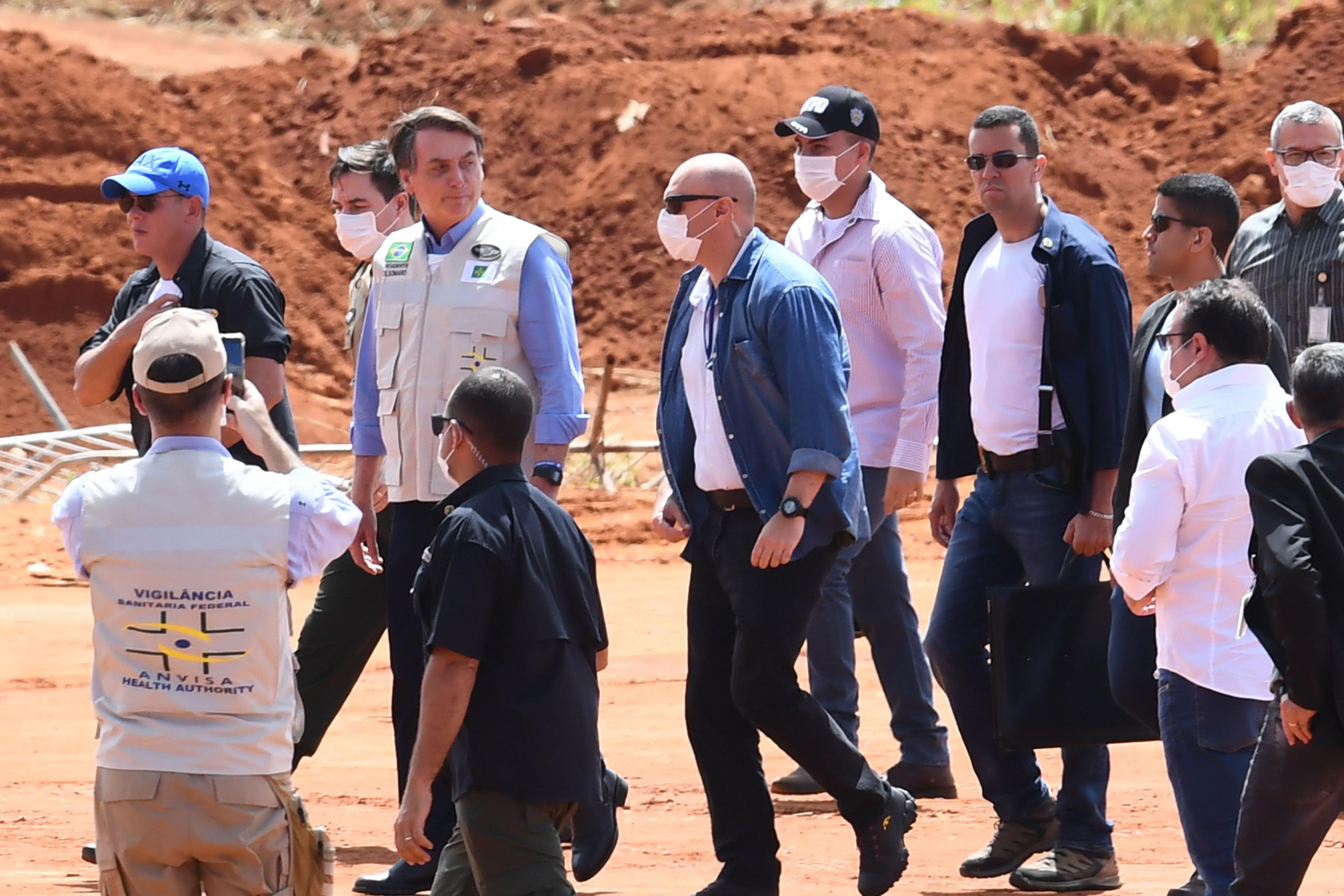 President Jair Bolsonaro (3-L) visits the construction site of a field hospital for people infected with the new coronavirus in Aguas Lindas, Goias State, Brazil on 11 April 2020.