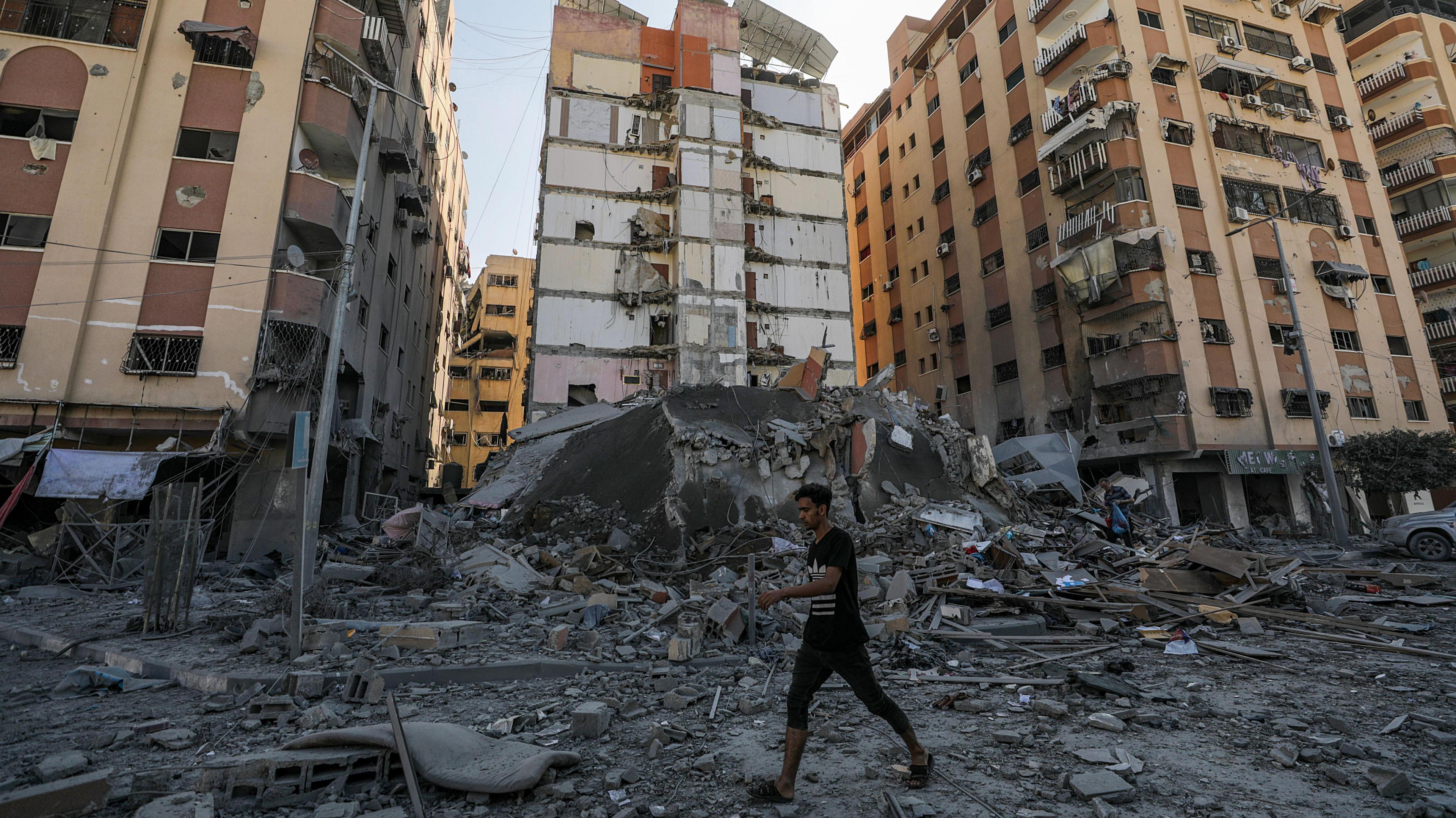 A man walks among the rubble of destroyed residential buildings in Gaza