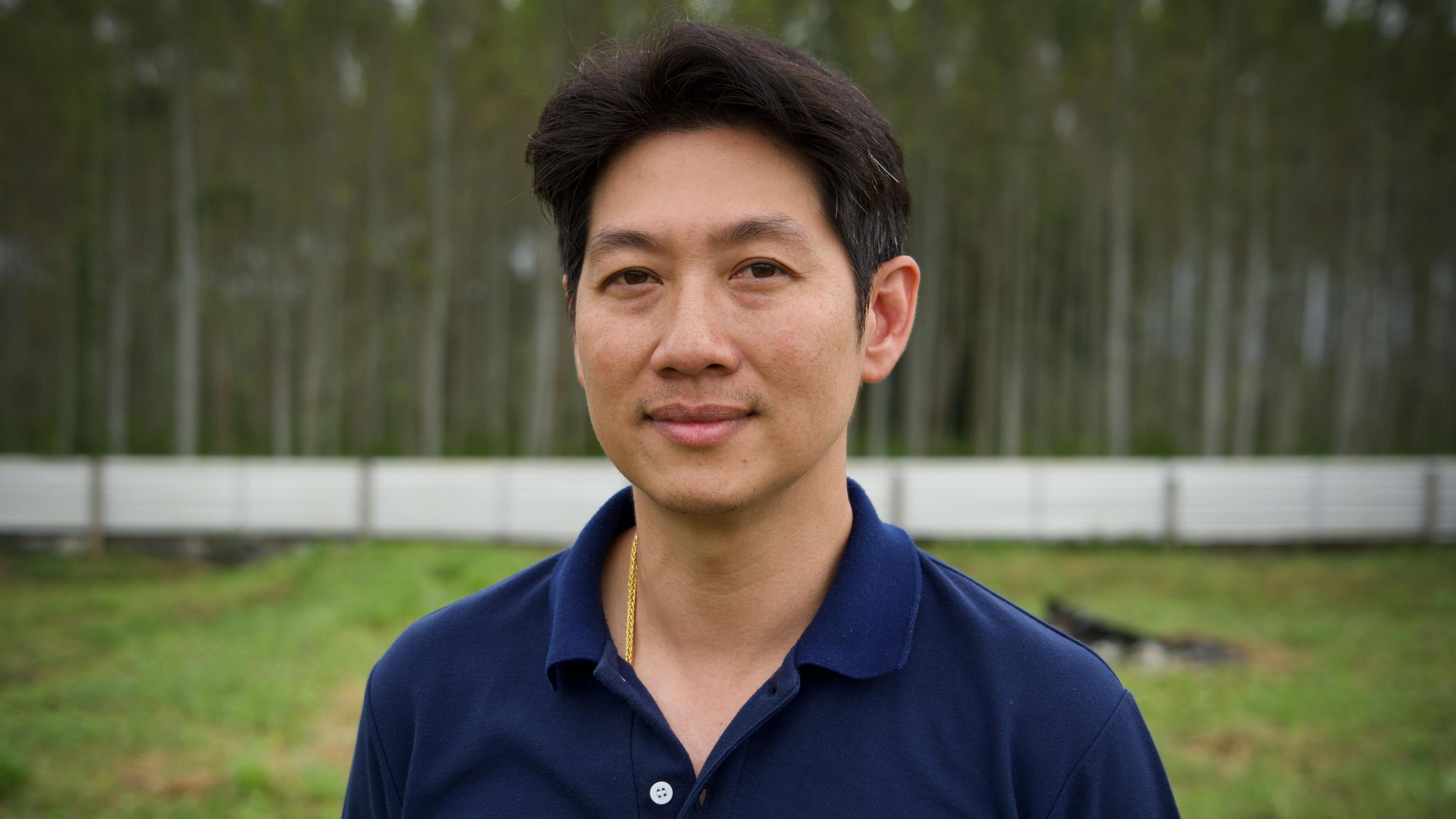 Worawut Siripun in a navy blue t shirt standing in his farm
