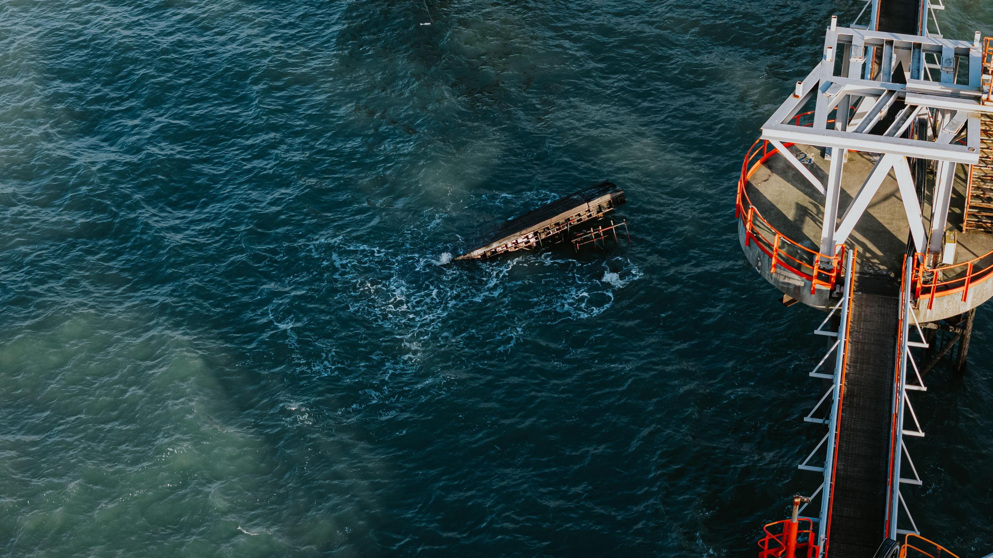 Metal object visible beneath the surface of the water. Industrial tower is visible on the right hand side. 