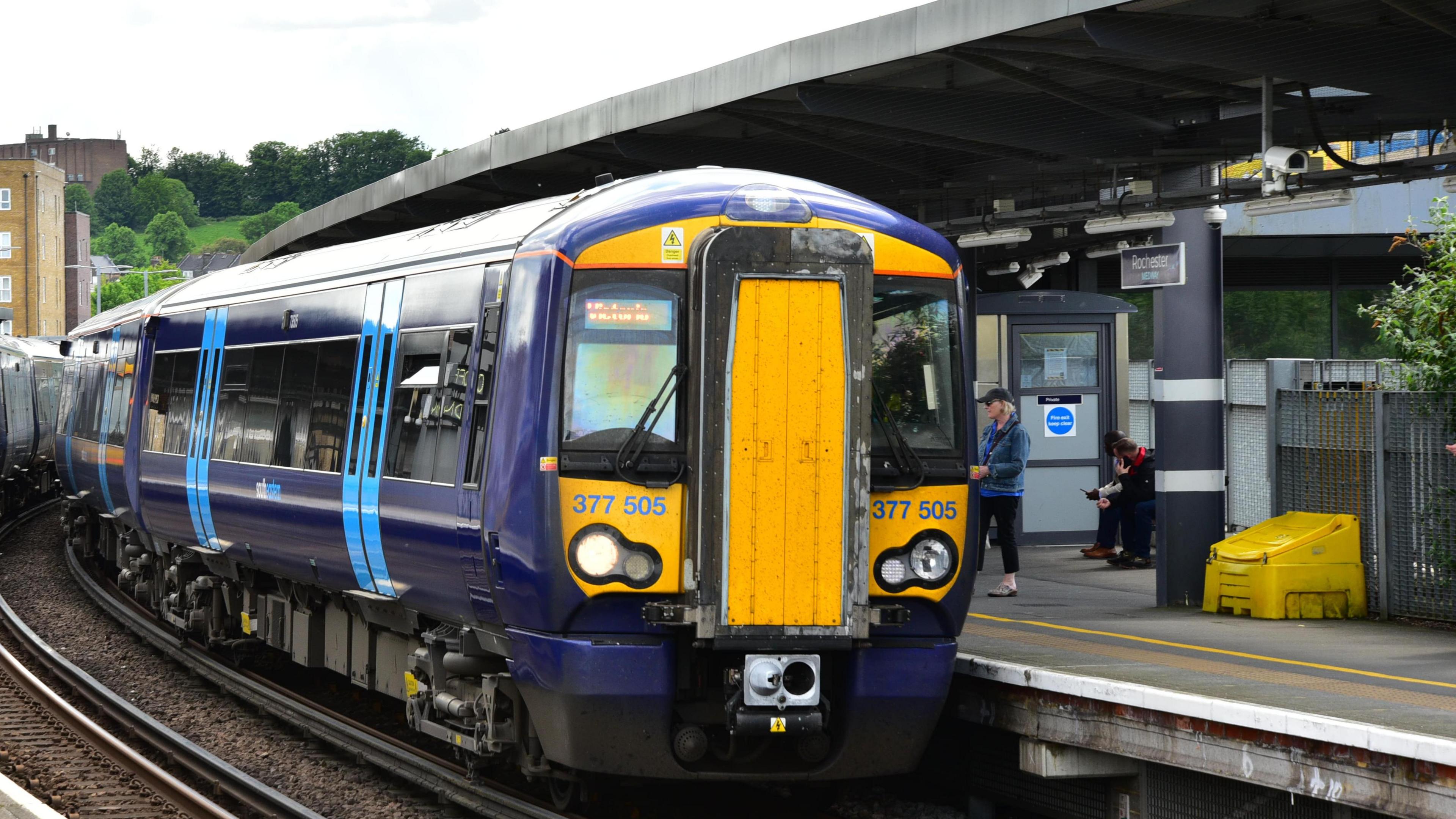 A dark blue Southeastern Class 377 train at a station platform