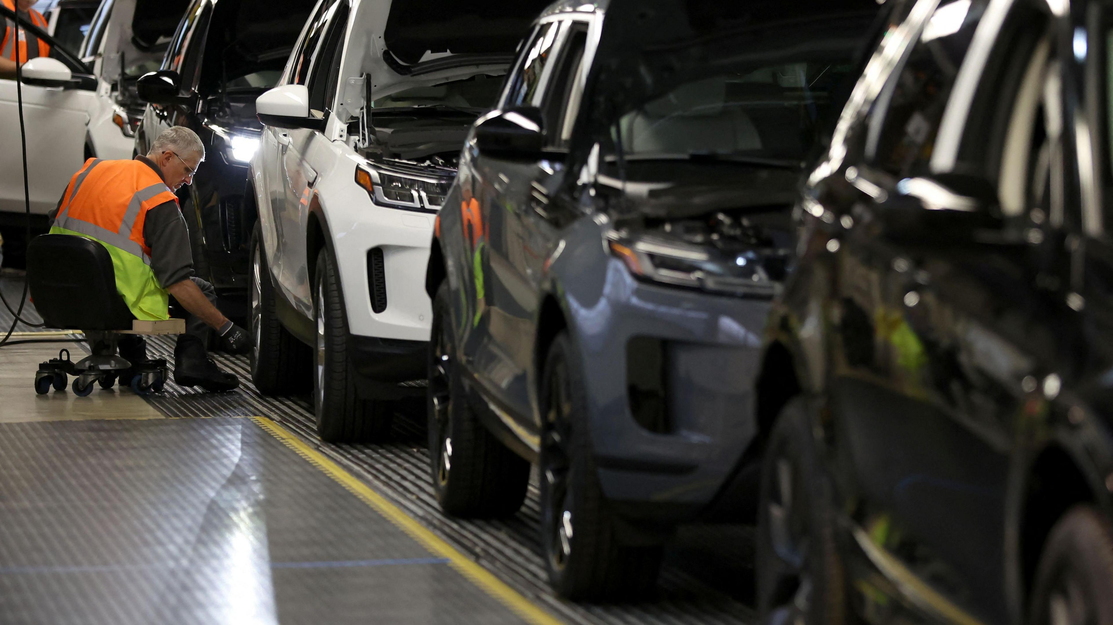 A staff member assembles Range Rover Evoque SUVs on the production line at Jaguar Land Rover's Halewood factory in Liverpool