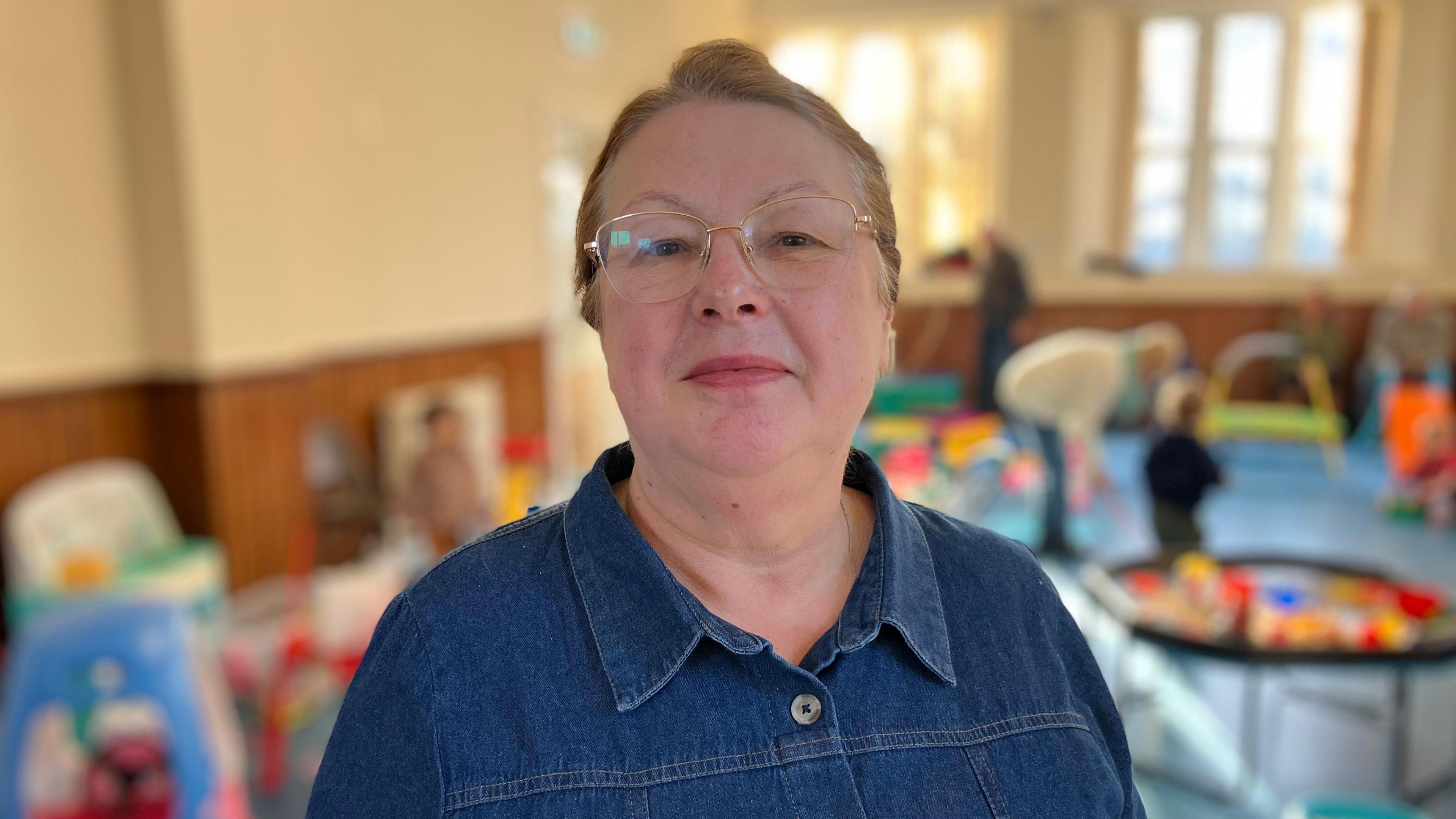 Alison Thomas mewn crys denim a sbectol