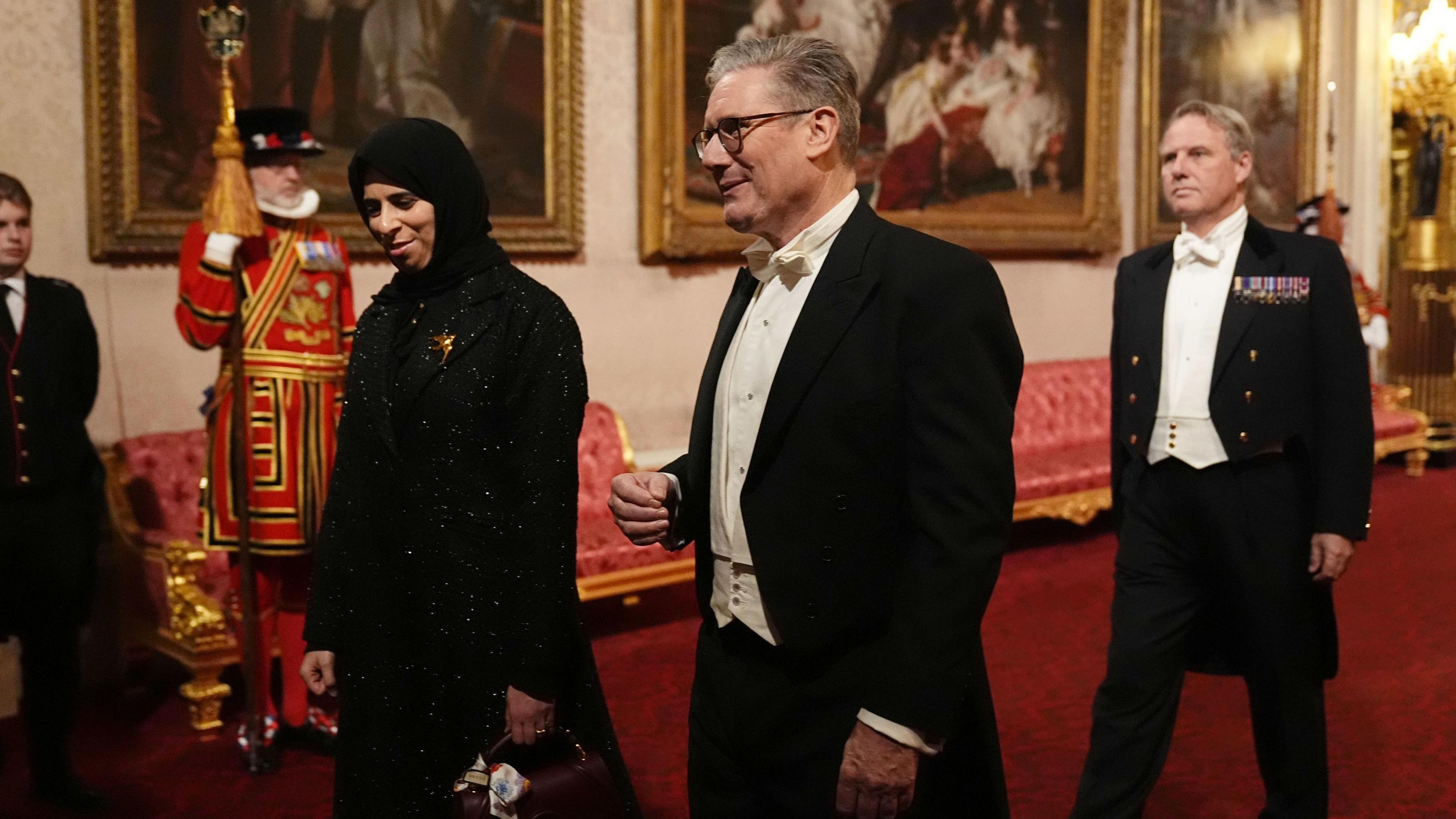 Lolwah Rashid Al Khater (L) and Keir Starmer (R) walking into the banquet