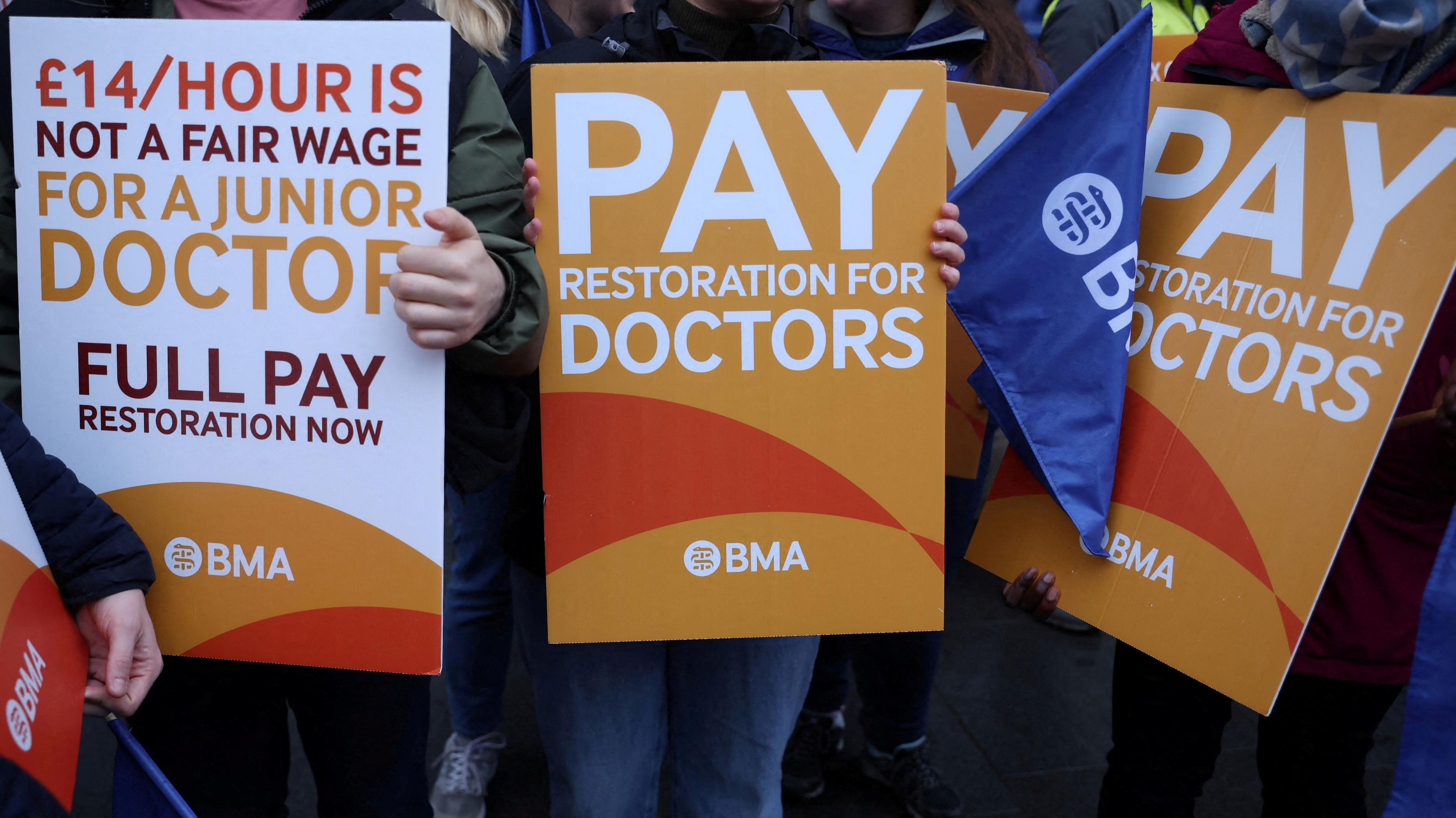 A group of signs being held by resident doctors striking last July in their calls for pay restoration