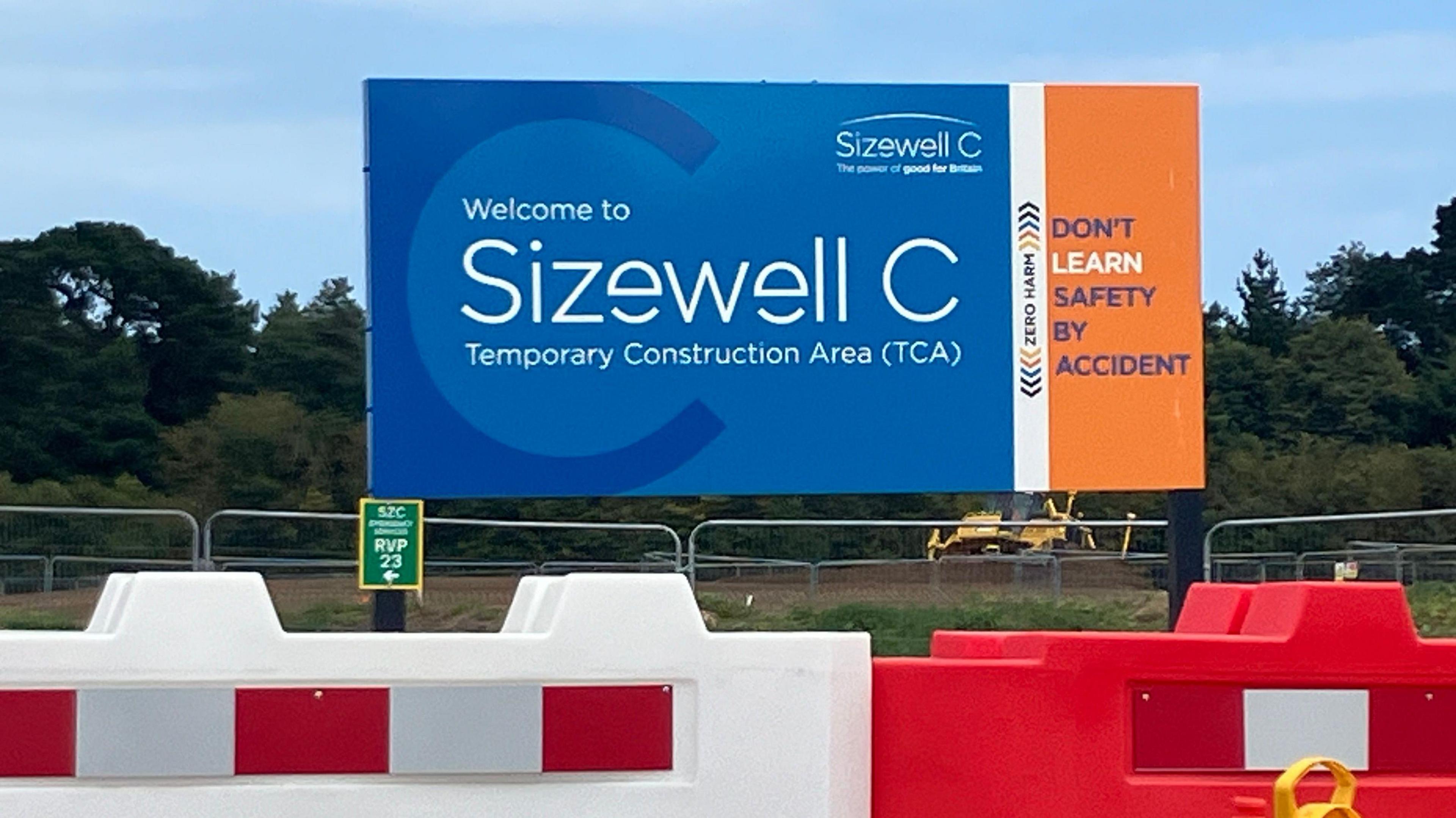 Sign on construction site welcoming people to Sizewell C 