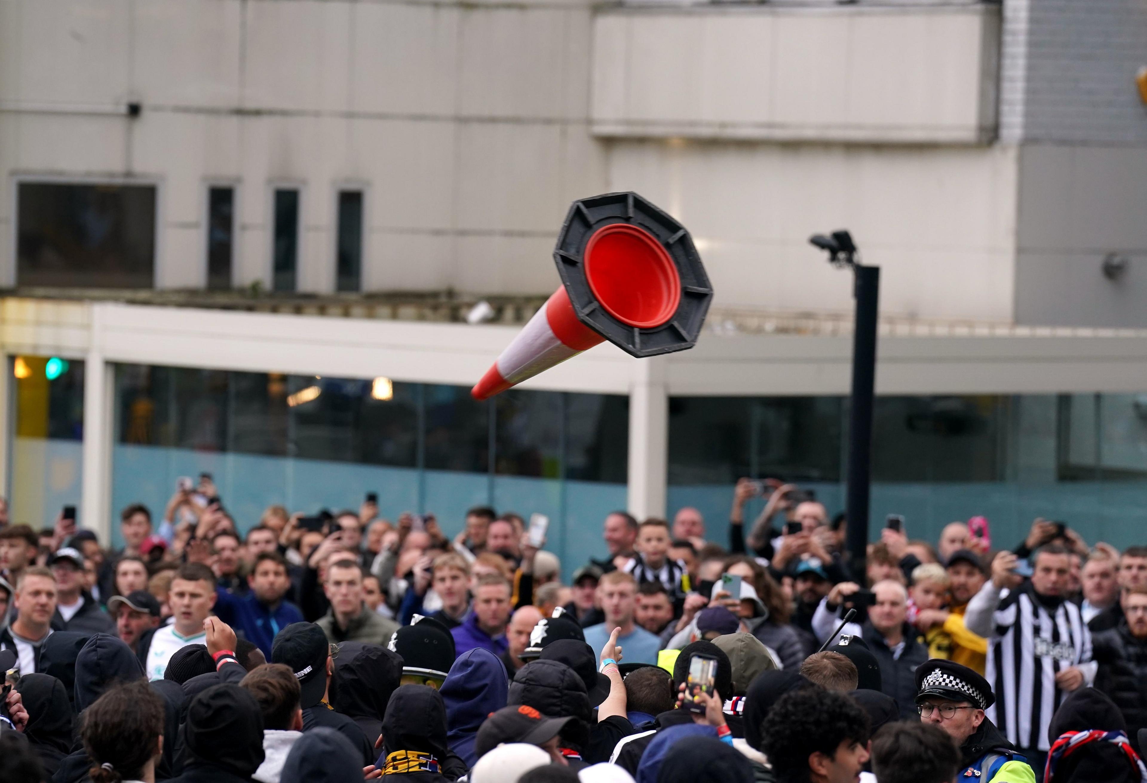 A cone in mid-air, thrown by someone in a crowd