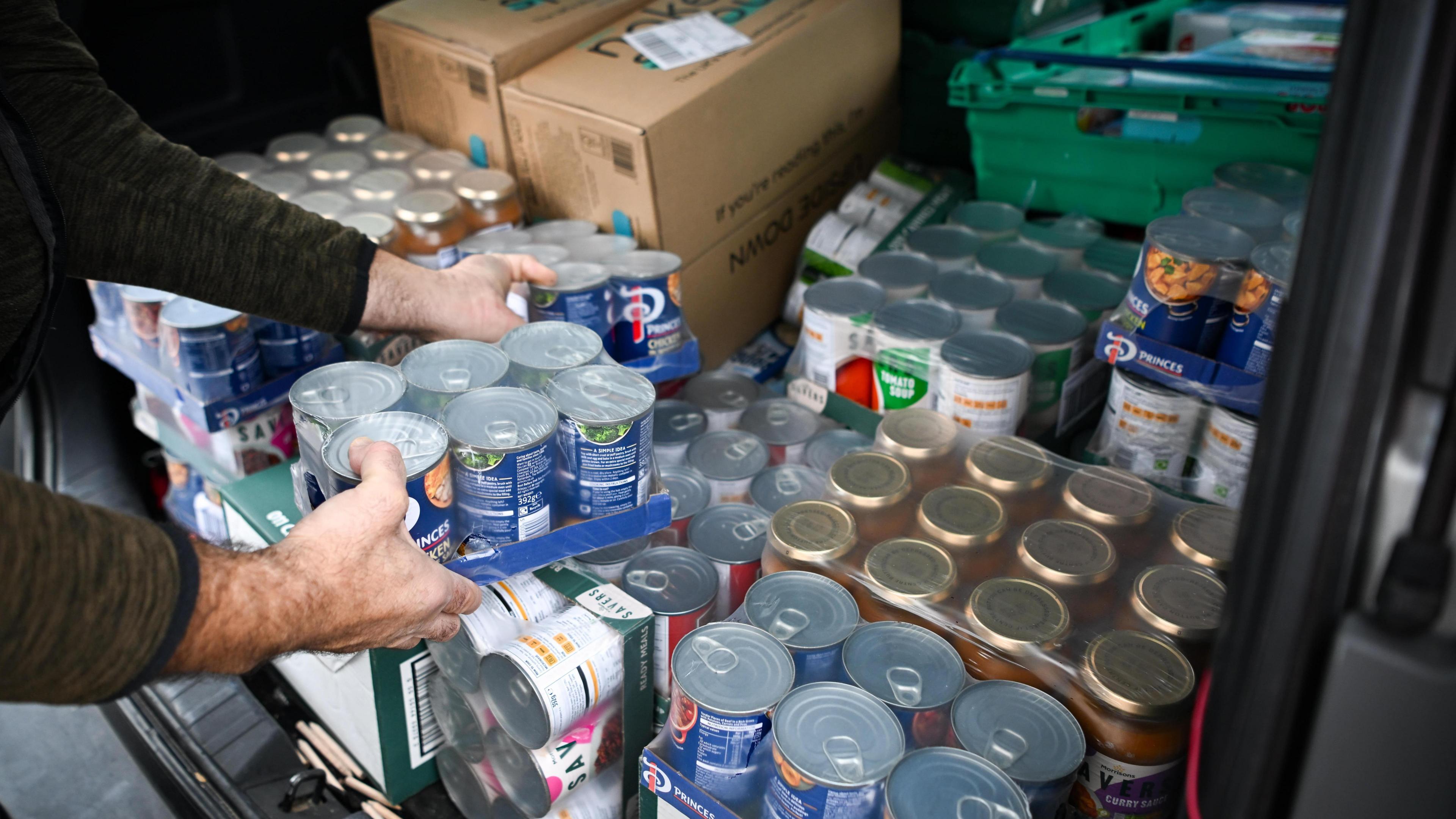 Stacks of canned foods apparently being loaded into a van