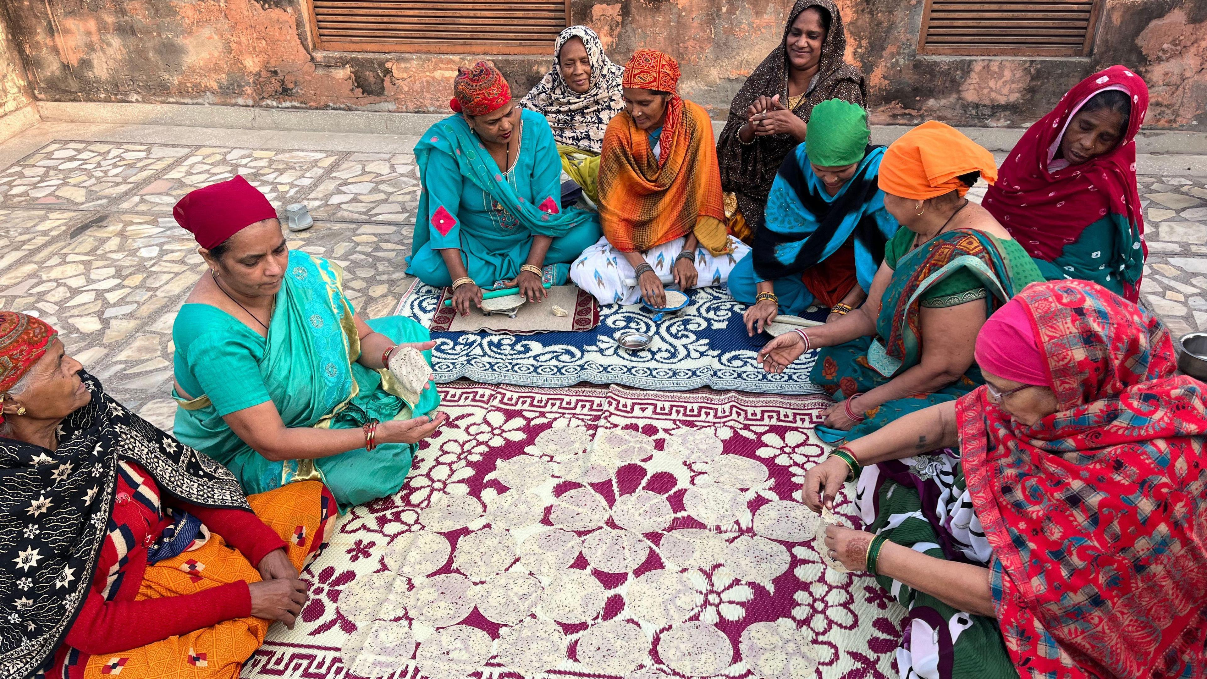 Women workers of the collective prepare poppadoms on a rooftop