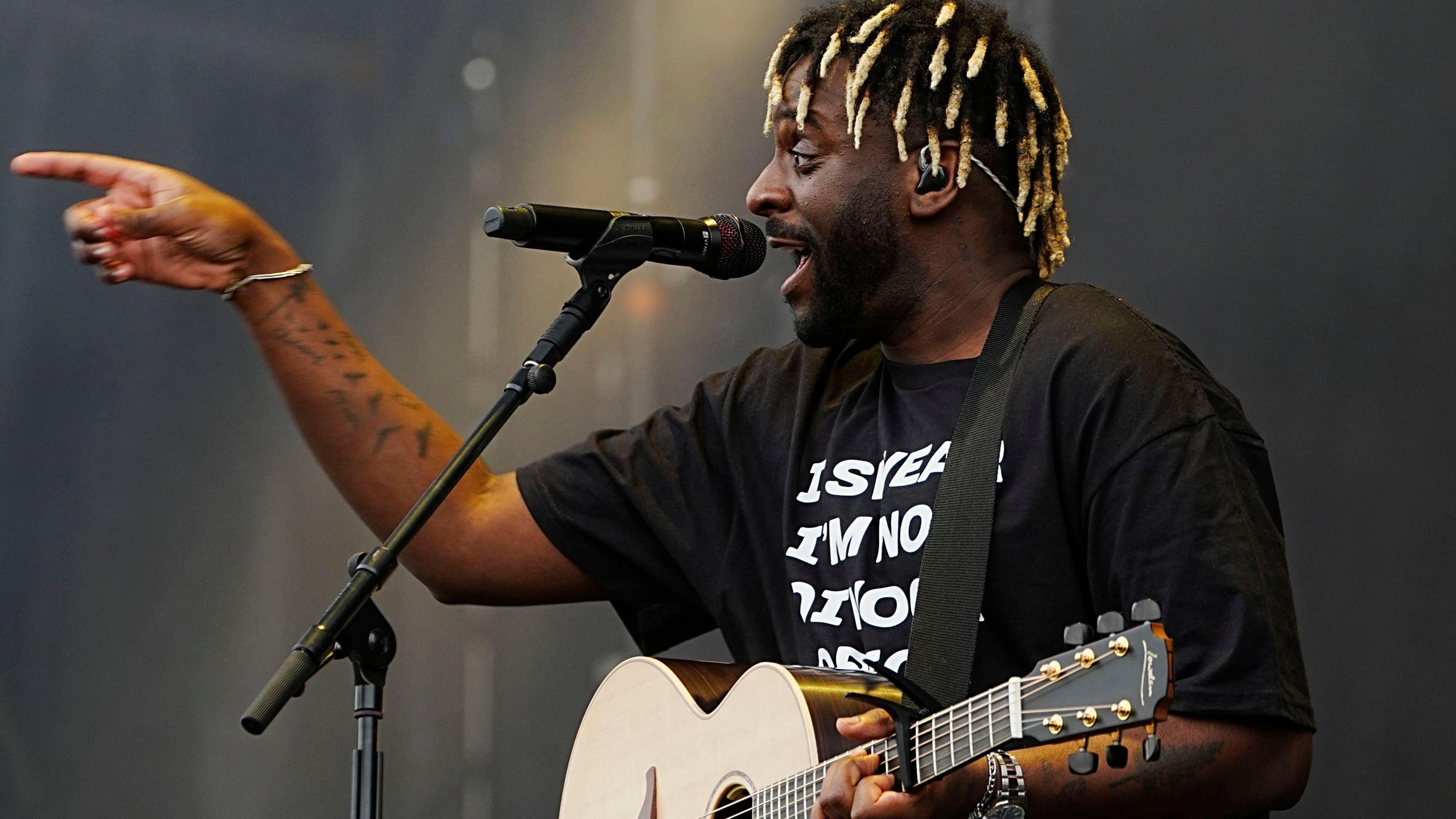 Myles Smith is seen pointing at the crowd while singing at Radio 1's Big Weekend