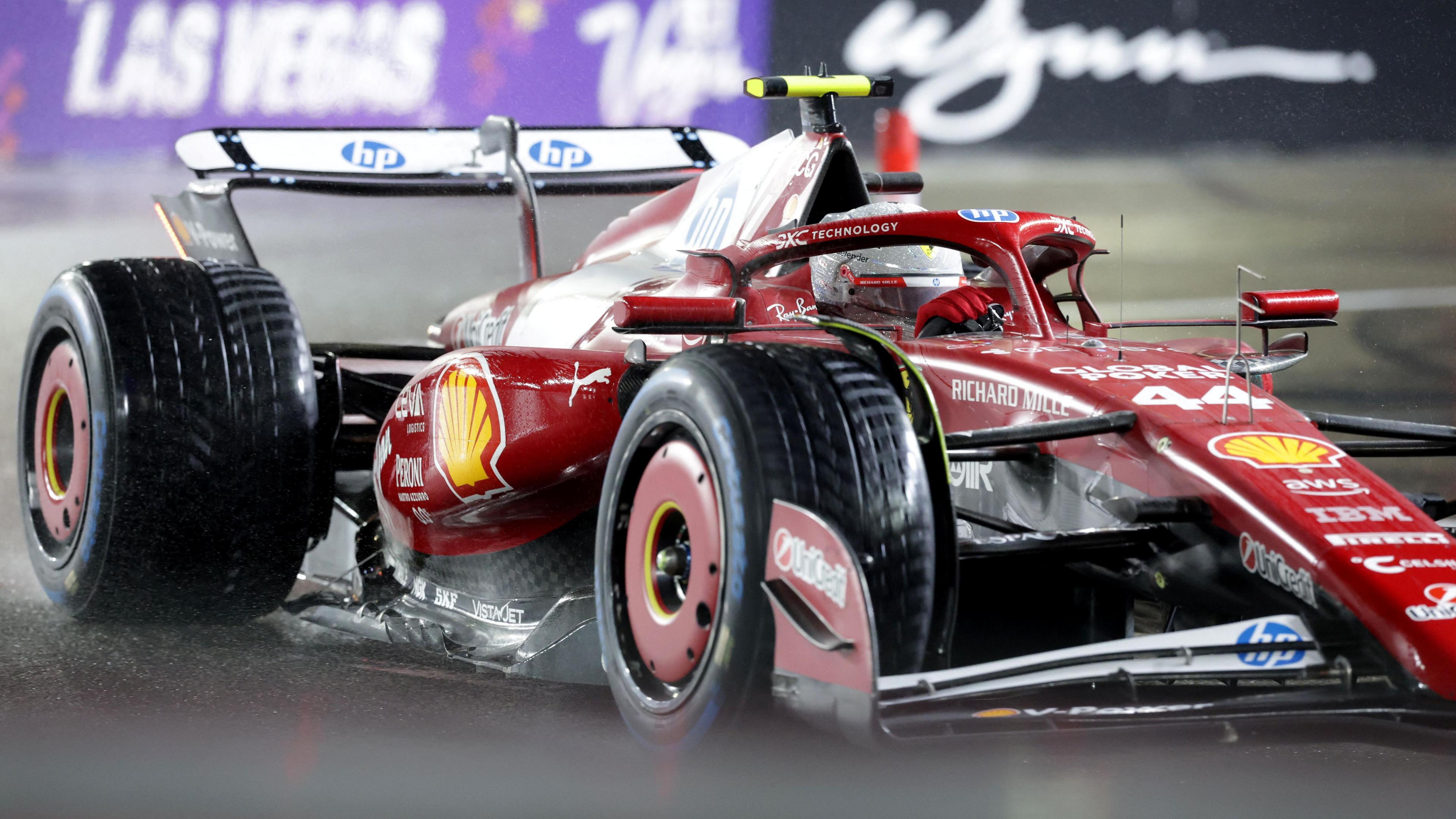 Lewis Hamilton steers his Ferrari as water is thrown up from the track during a wet Las Vegas Grand Prix qualifying