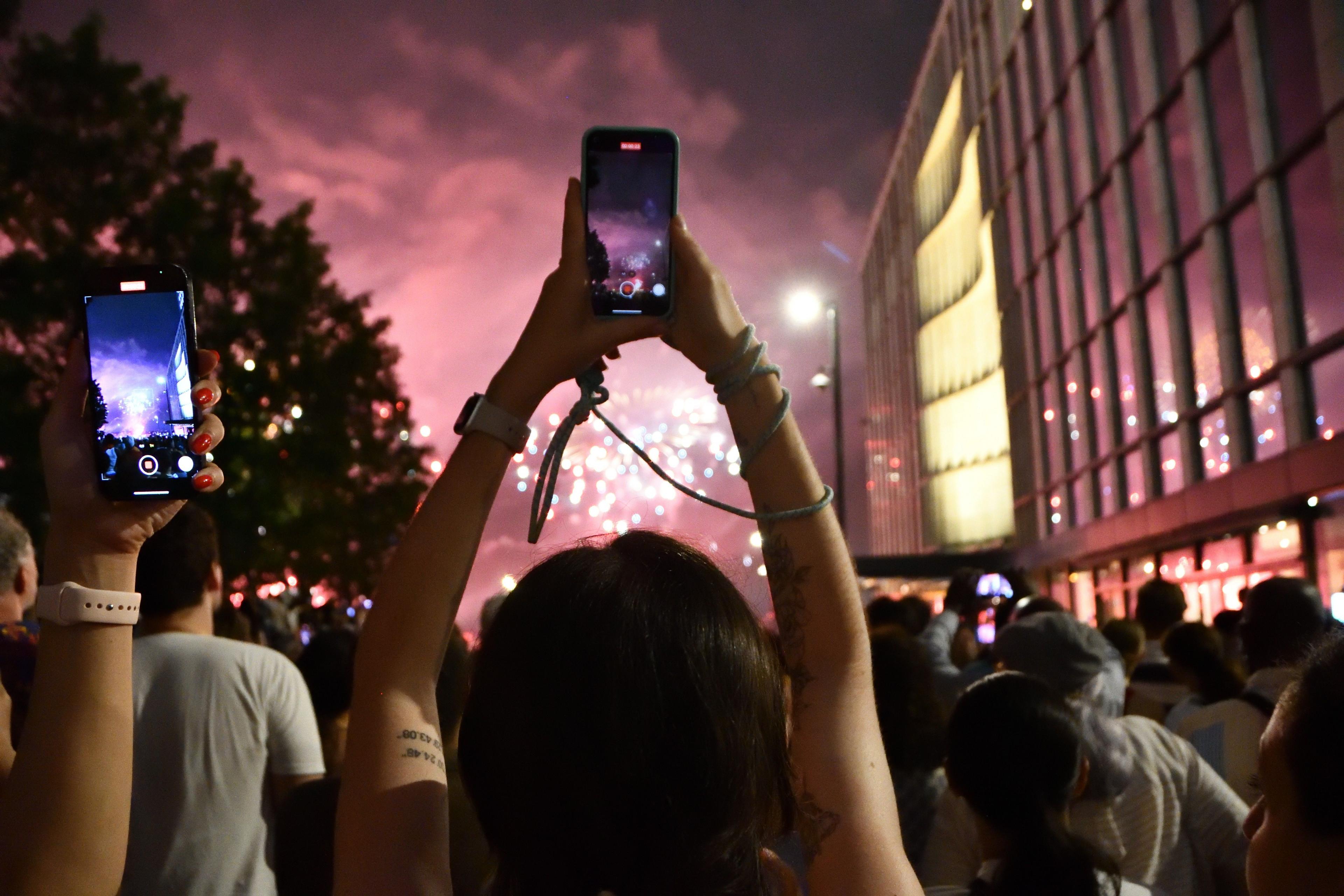 An arch formed by the arms of a person holding up a mobile phone to take a picture