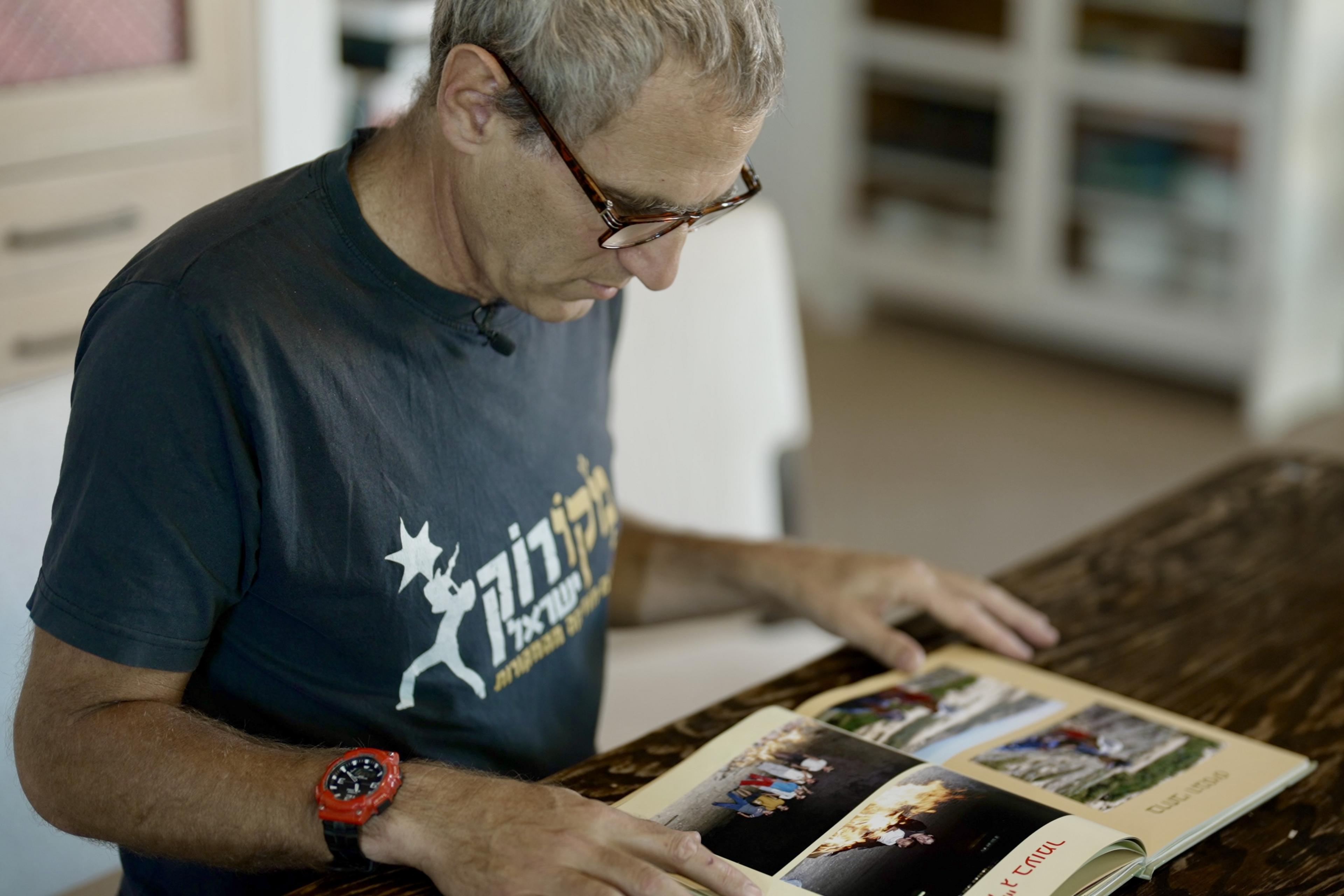 Ido Frommer looks at a photo album