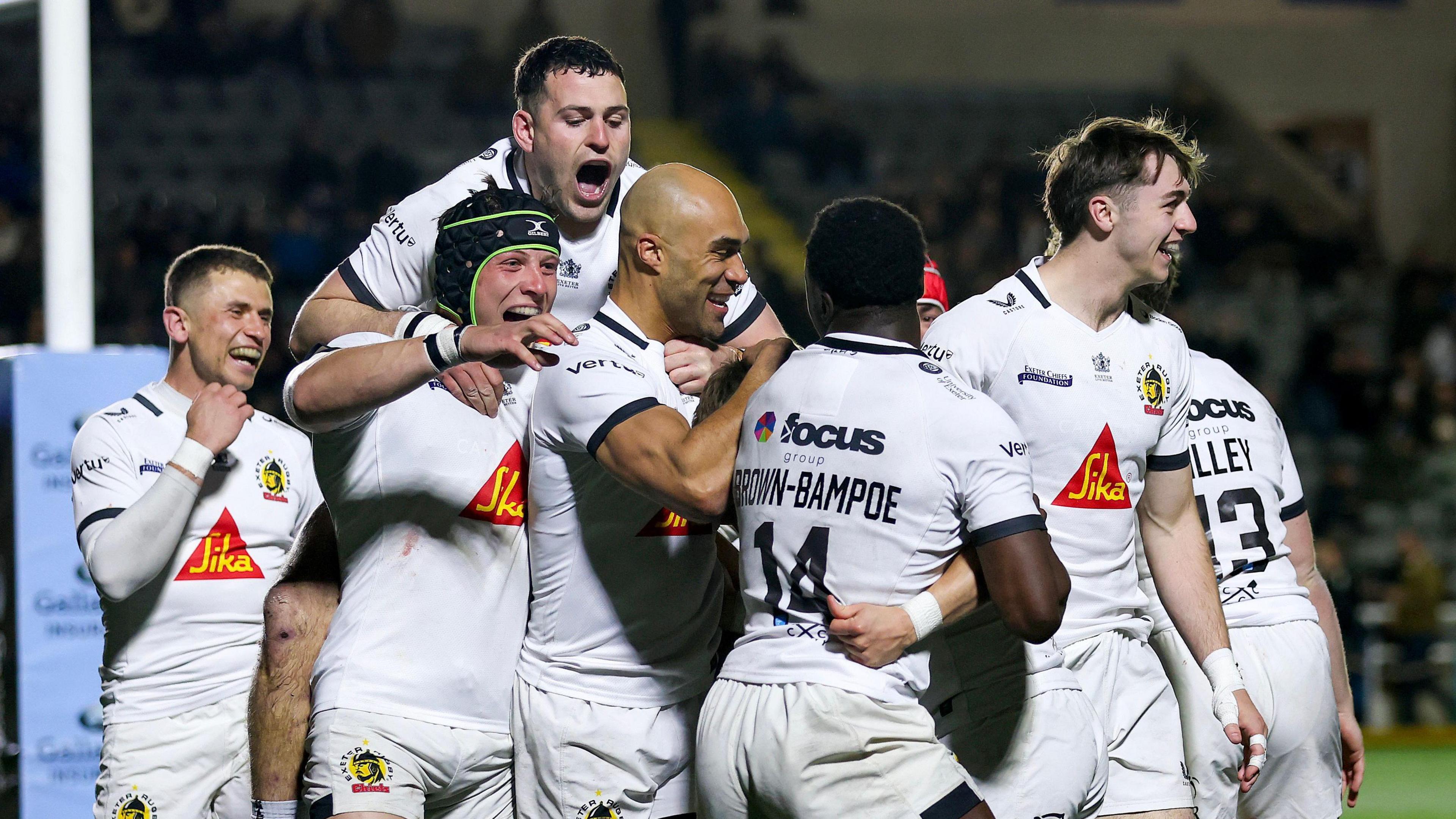 A group of Exeter players celebrate one of their six tries away to Newcastle