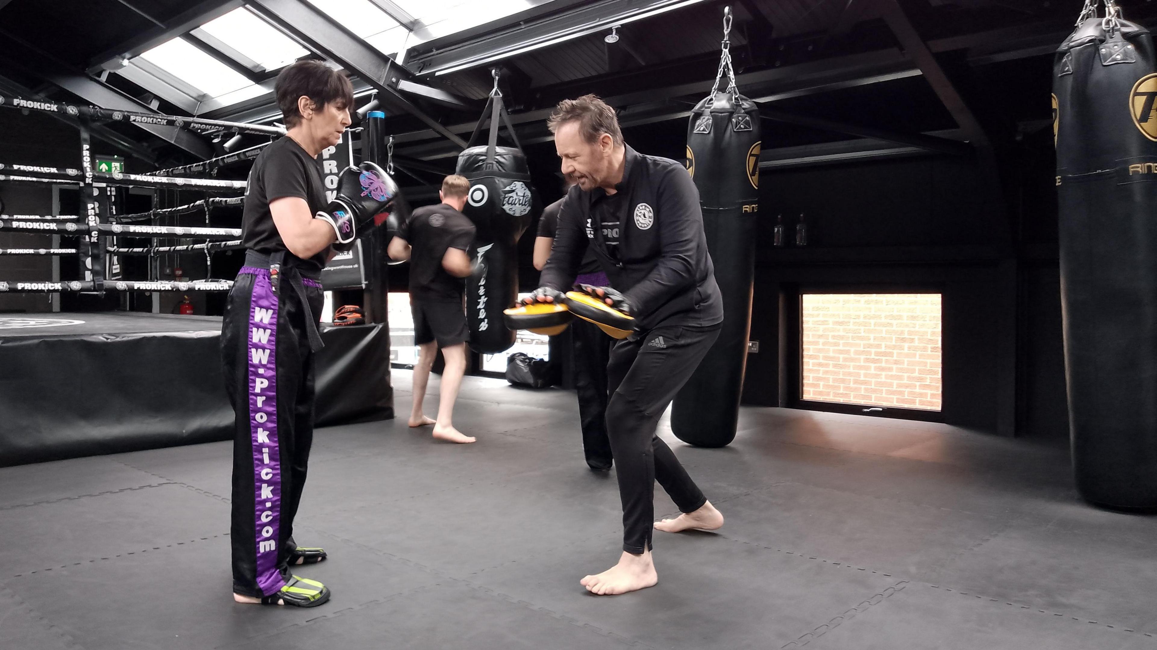 Billy Murray holding pads for a woman