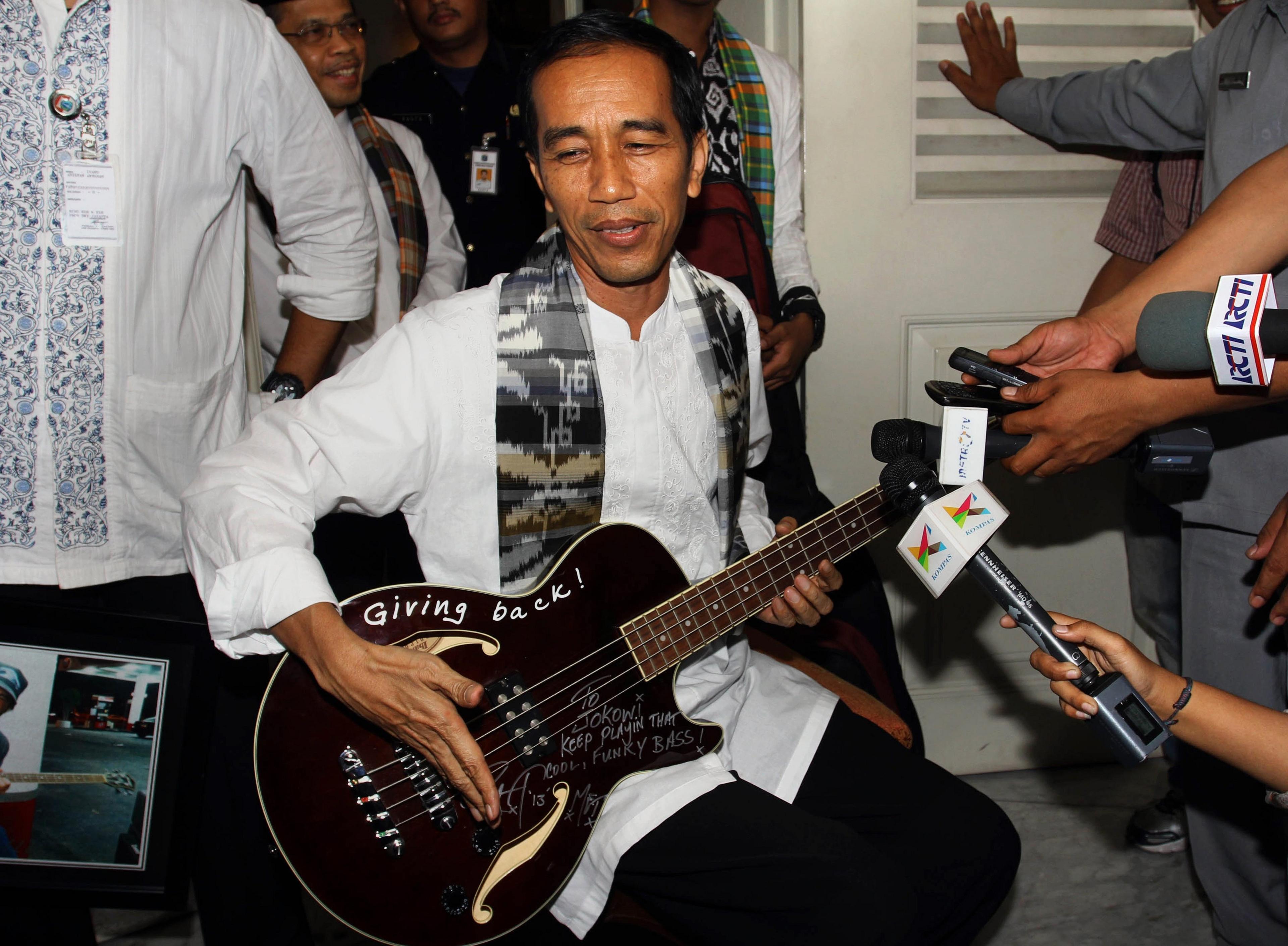 Joko Widodo playing a signed guitar