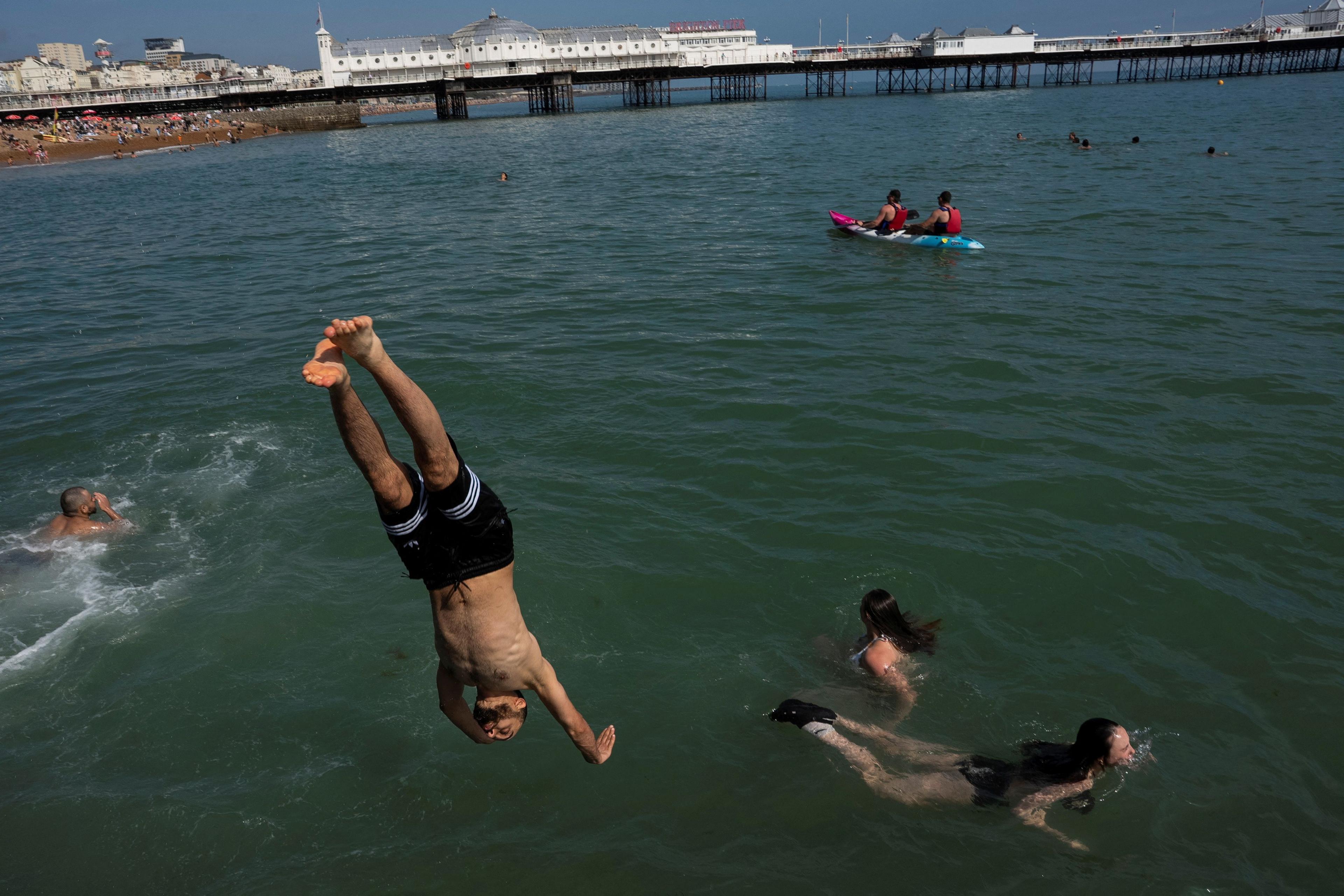 A person diving into the sea by Brighton pier
