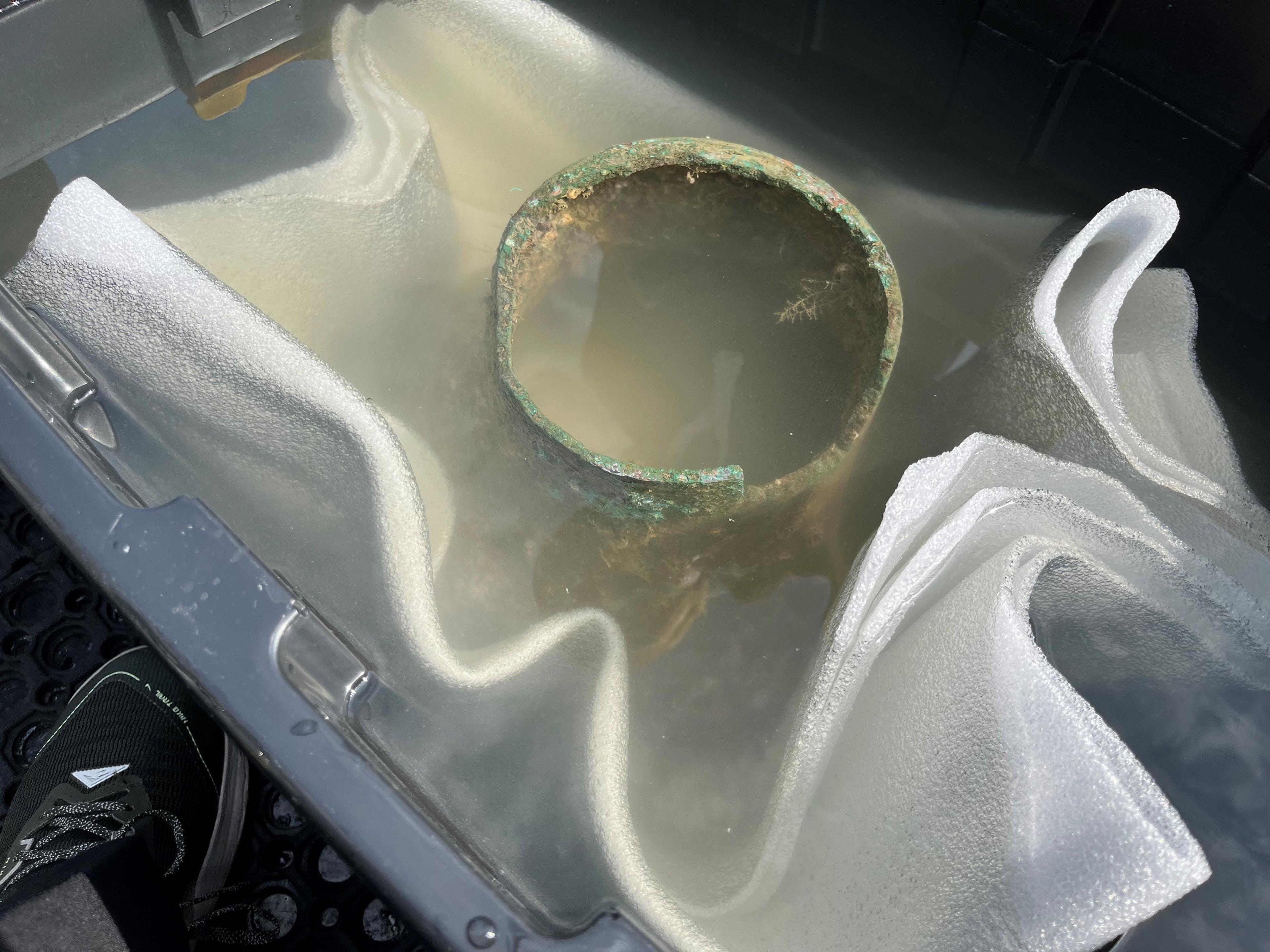 The top of the ship's bell in a large container of seawater