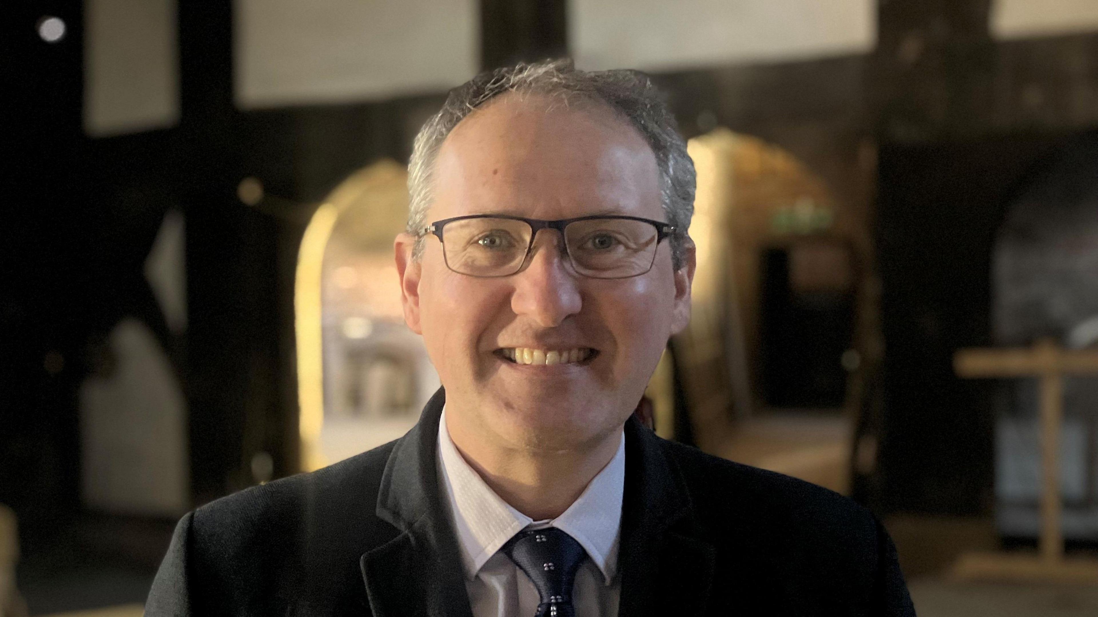 Photograph of Michael Guy, who is the Chief Executive at Heritage Trust North West. He is pictured inside Baguley Hall in Wythenshawe.