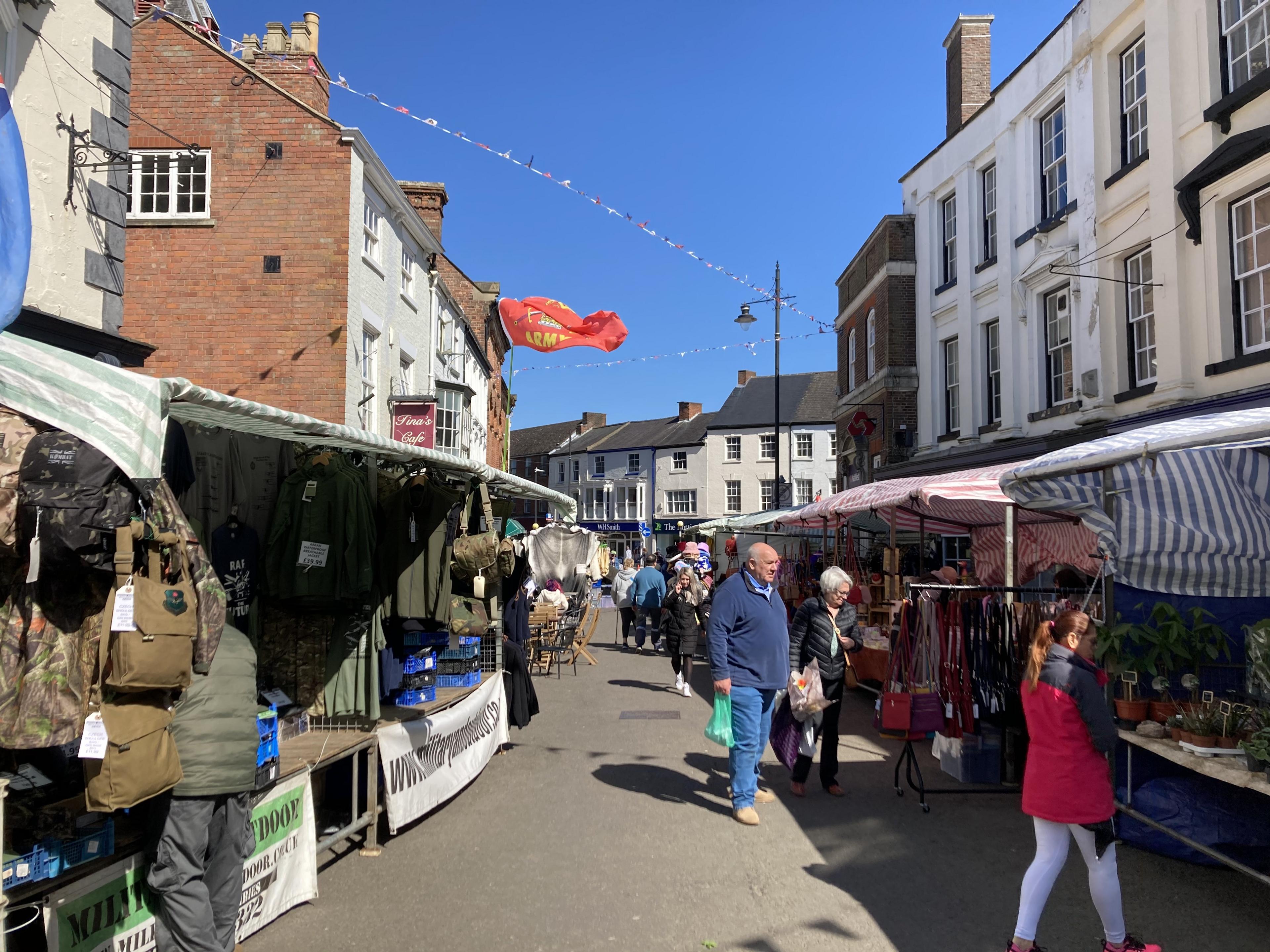 Shoppers go between the market stalls in the centre of Louth.