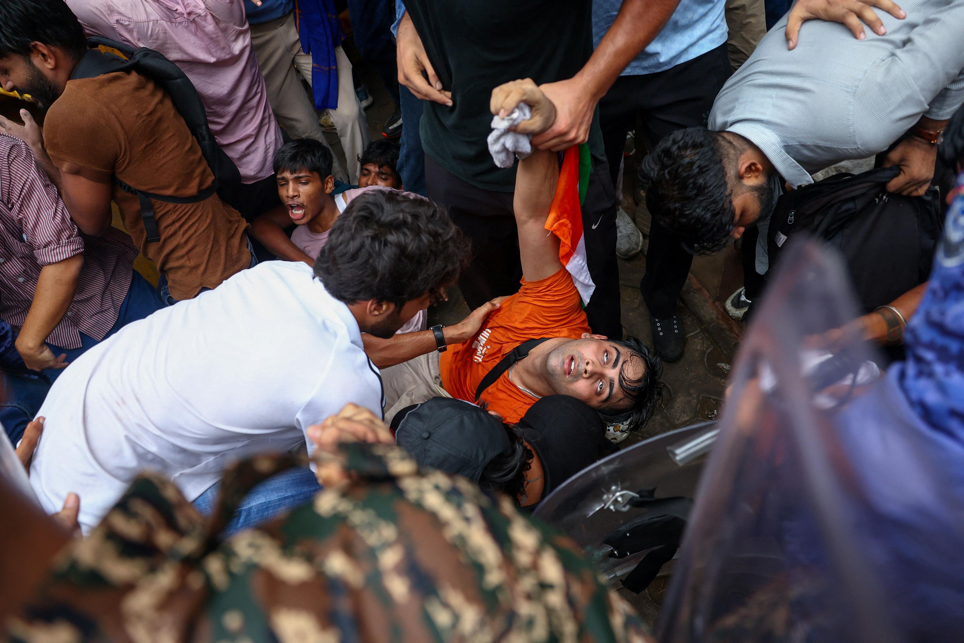 A protester falls down following clashes with members of law enforcement as supporters of India's Cockroach Janta Party demonstrate on the opening day of the Indian parliament's monsoon session, demanding the resignation of Education Minister Dharmendra Pradhan over exam paper leaks, in New Delhi, India, 20 July, 2026. REUTERS/Anushree Fadnavis
