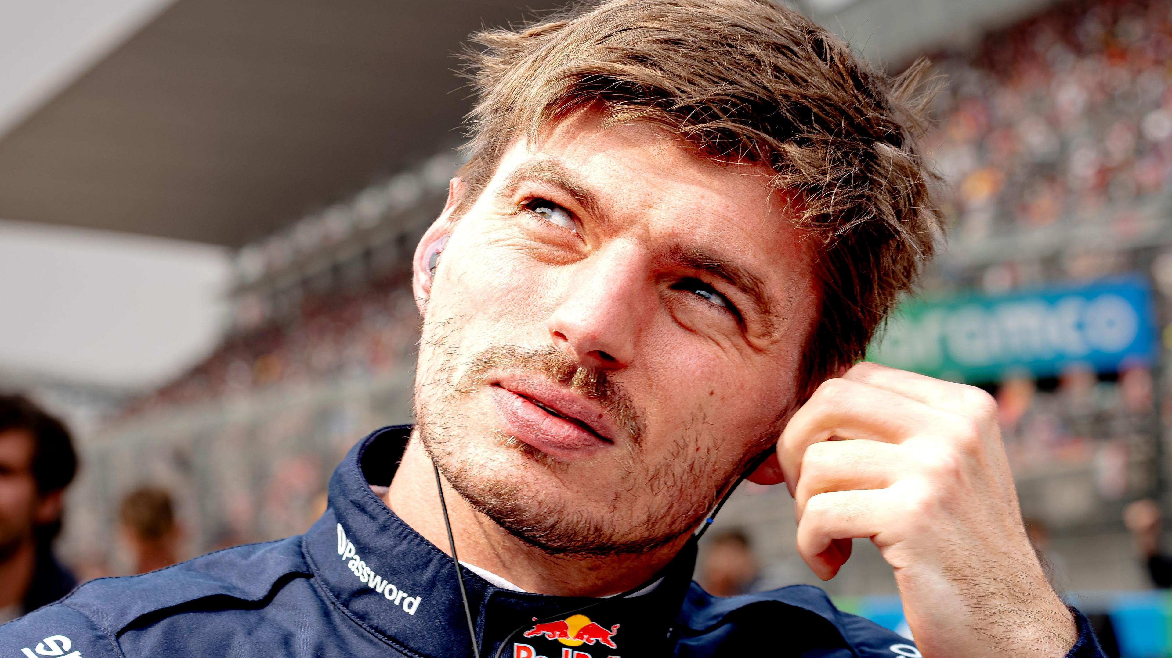 Max Verstappen removes his ear protectors after getting out of his car following the Japanese Grand Prix