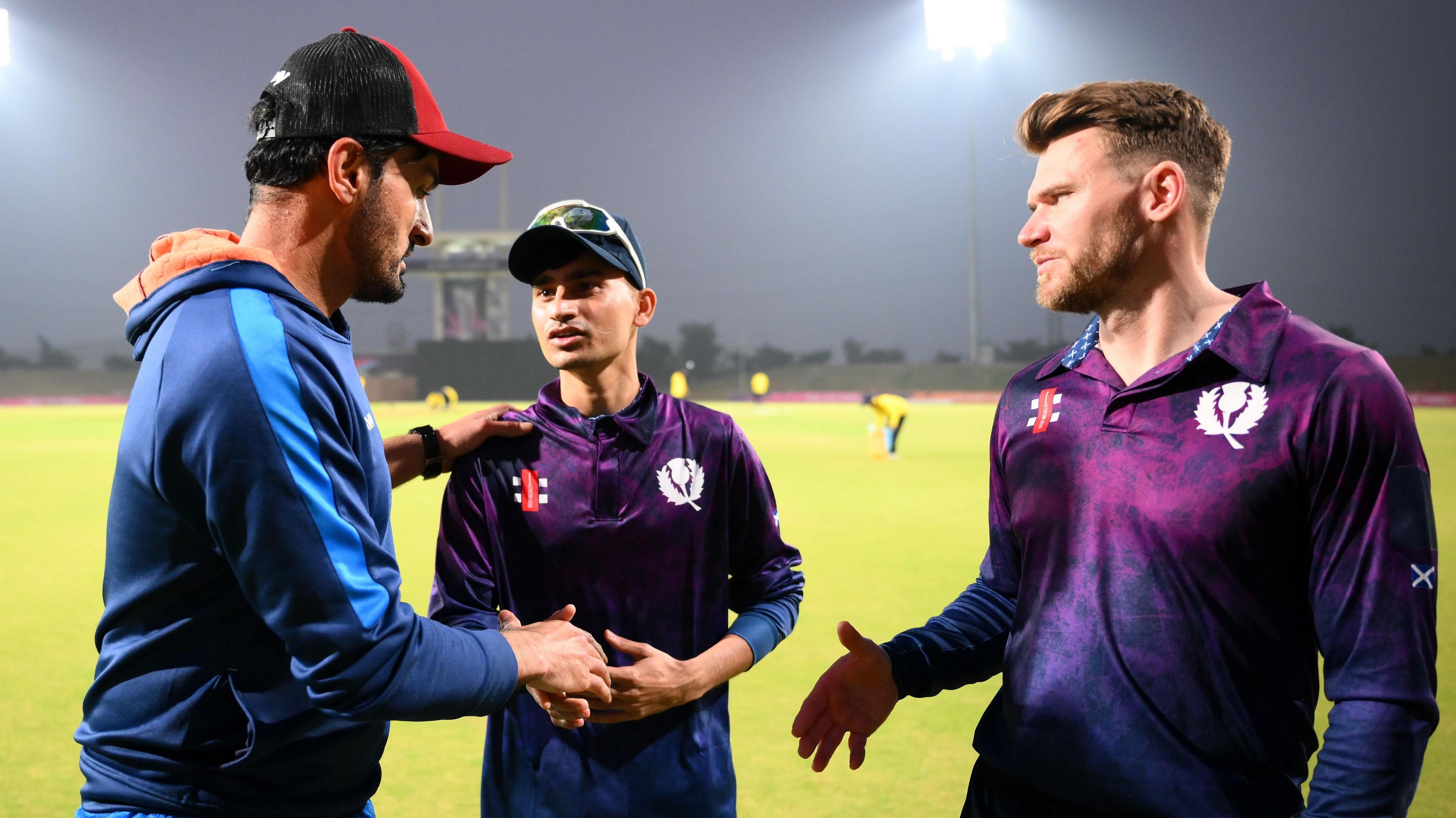 Zainullah Ihsan (centre) - accompanied by Scotland captain Richie Berrington (right) - chats to Afghanistan bowling coach Hamid Hassan