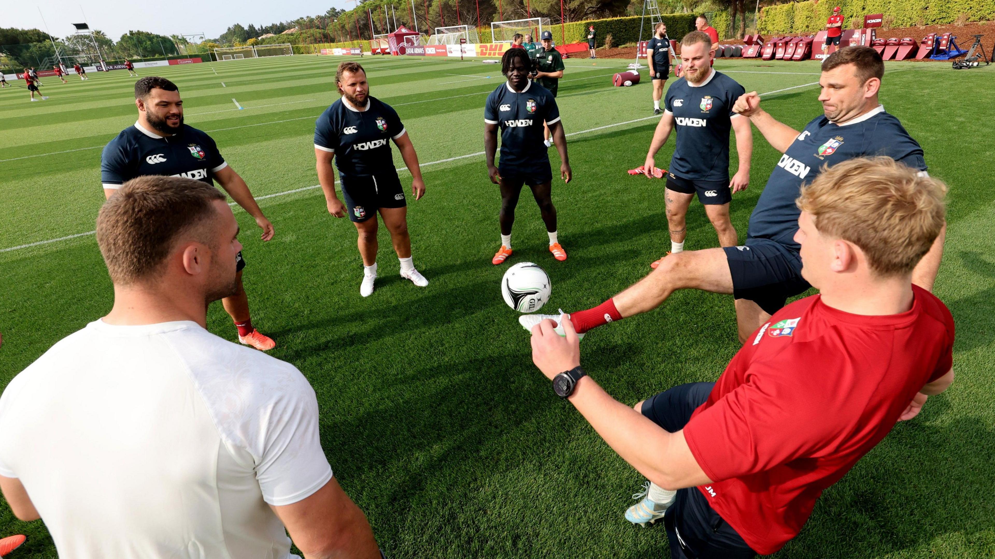 Lions players do a football warm-up
