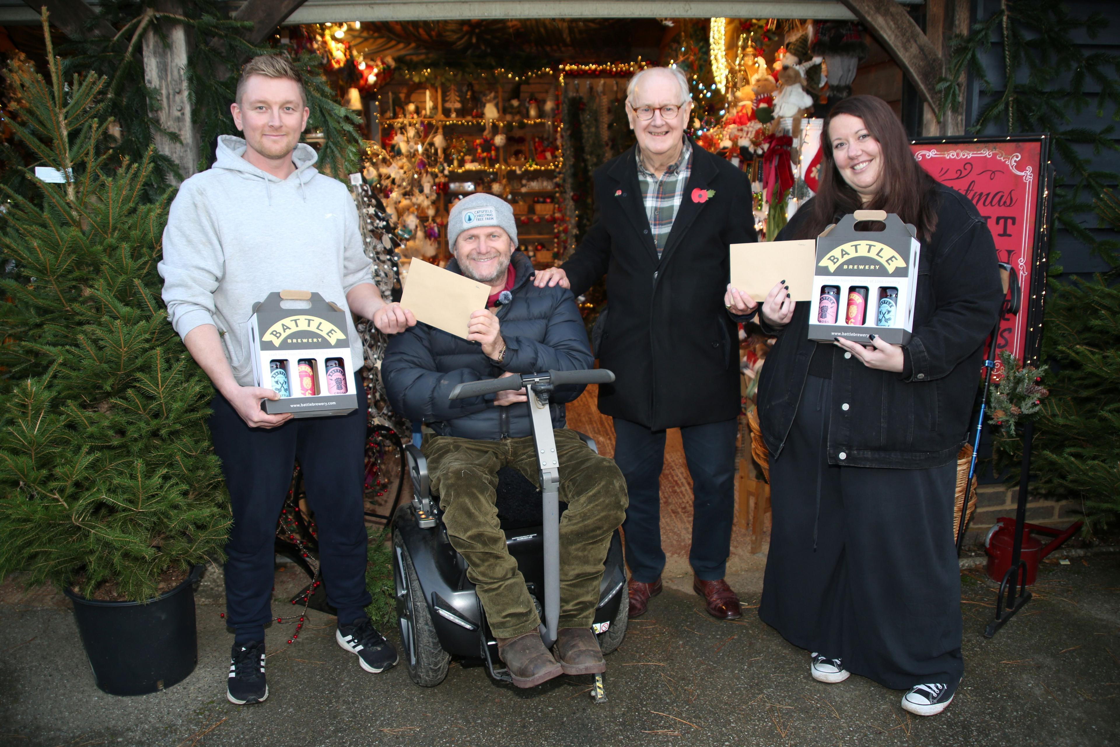The male and female winners, James Gardiner and Louise Thompson, pictured alongside Clive Collins, the owner of Catsfield Christmas Tree Farm, and Mike Corfield of Battle Brewery which co-sponsored the event. James and Louise can be seen holding their prizes.