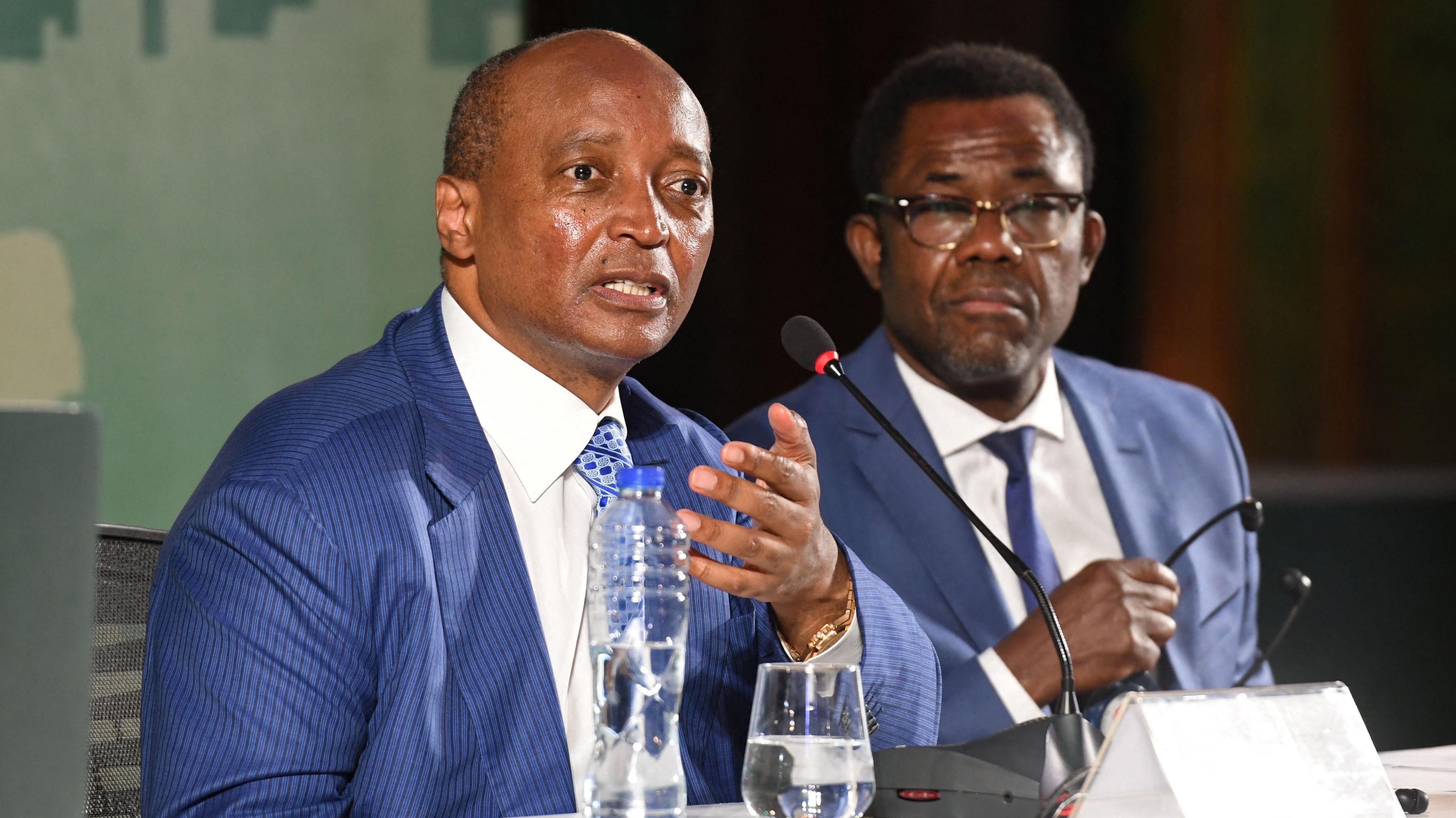 Caf president Patrice Motsepe (left) and secretary general Veron Mosengo-Omba (right) wear blue suits and ties and sit at a desk to give a press conference during the Confederation of African Football's extraordinary general assembly in Cairo