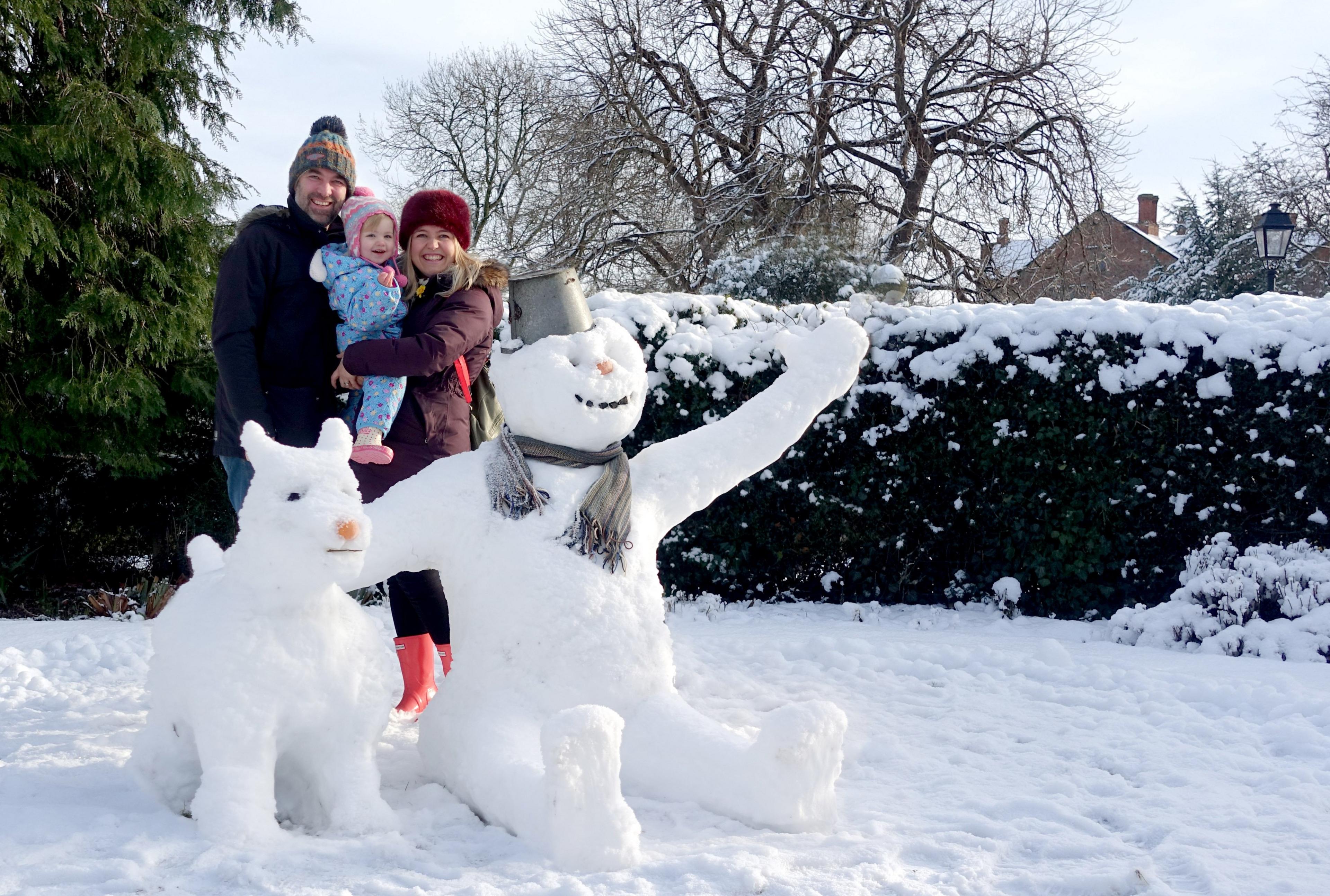 Snowman and dog with parents and daughter