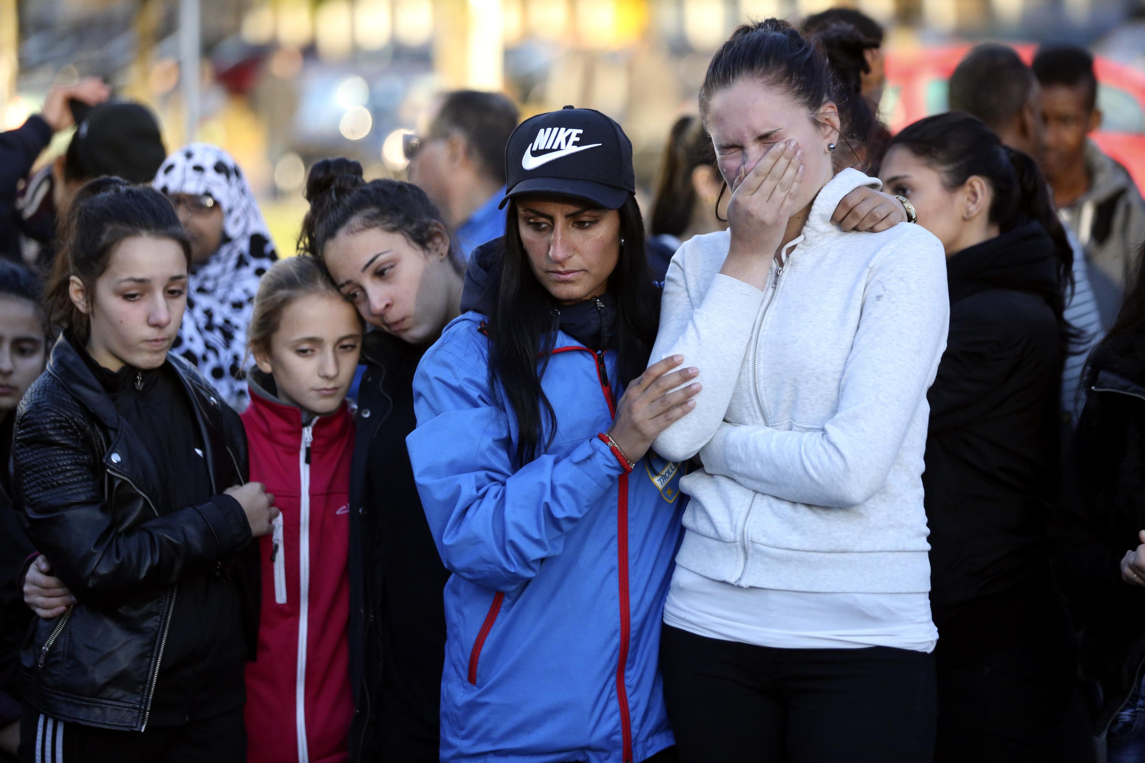 People stand outside Kronan school after Thursday"s attack, in Trollhattan, Sweden