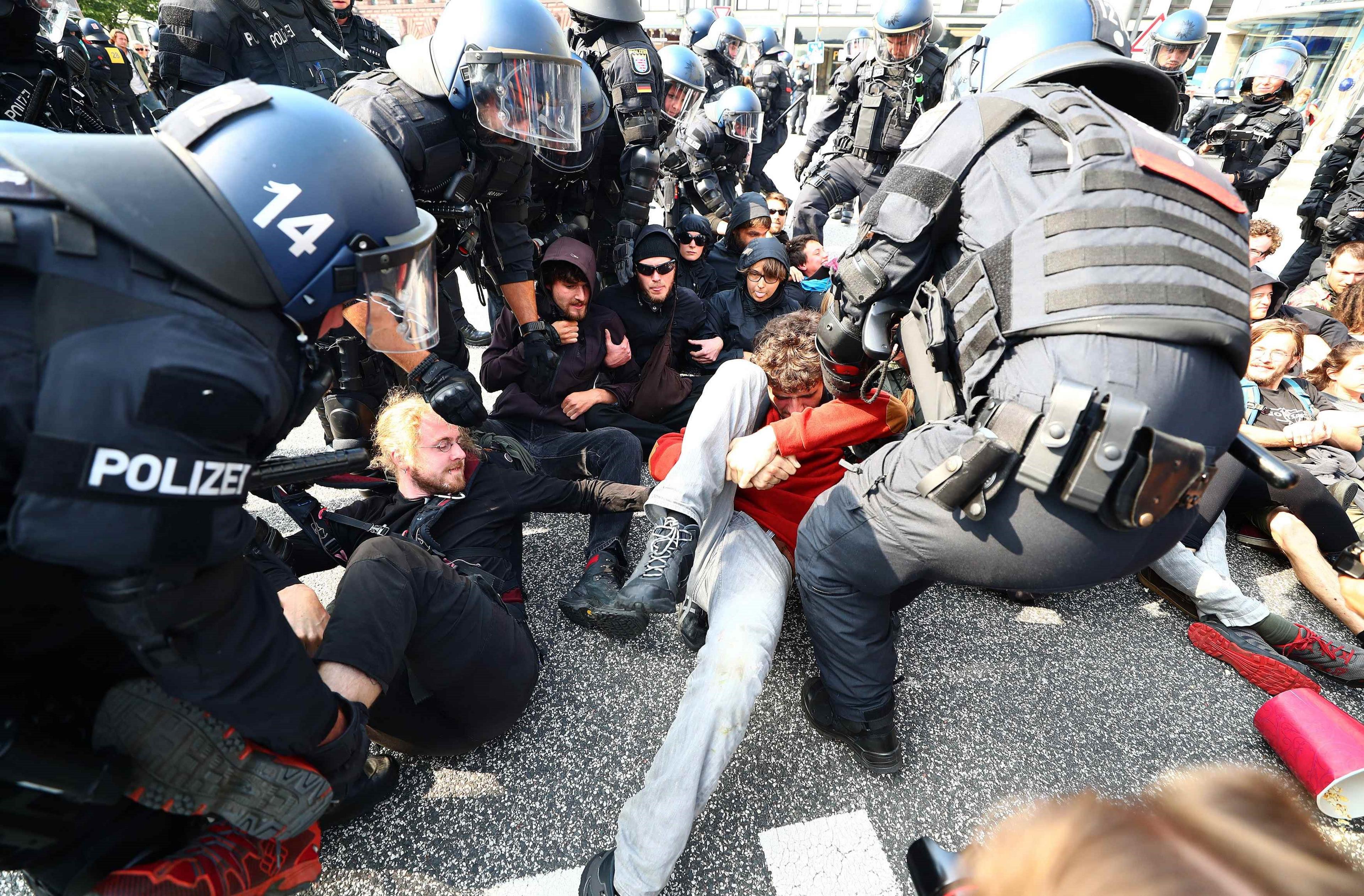 German police remove protesters who are blocking a street at a demonstration during the G20 summit in Hamburg, 7 July