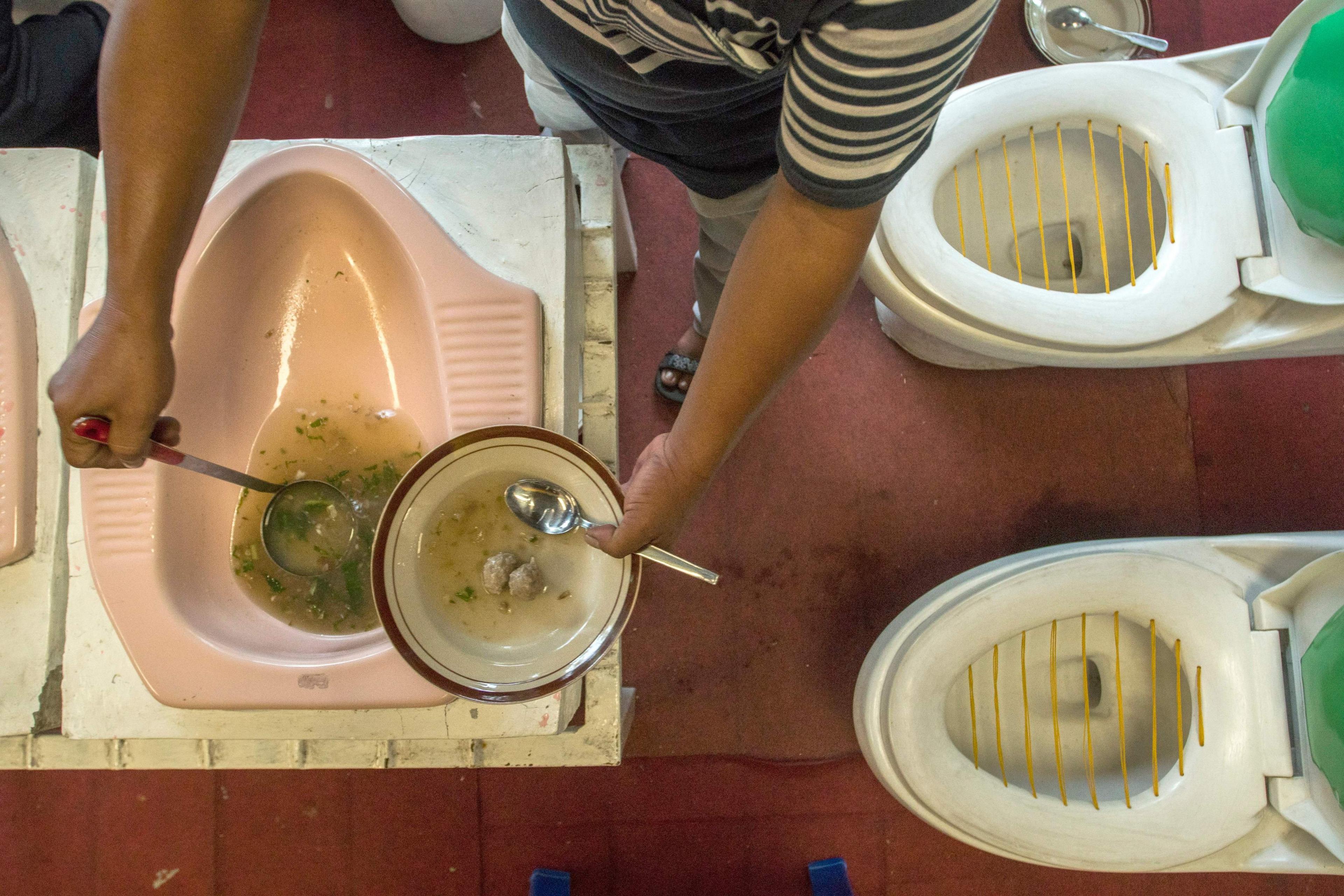 The chef serves meatball stew from a toilet pan at the Toilet Cafe