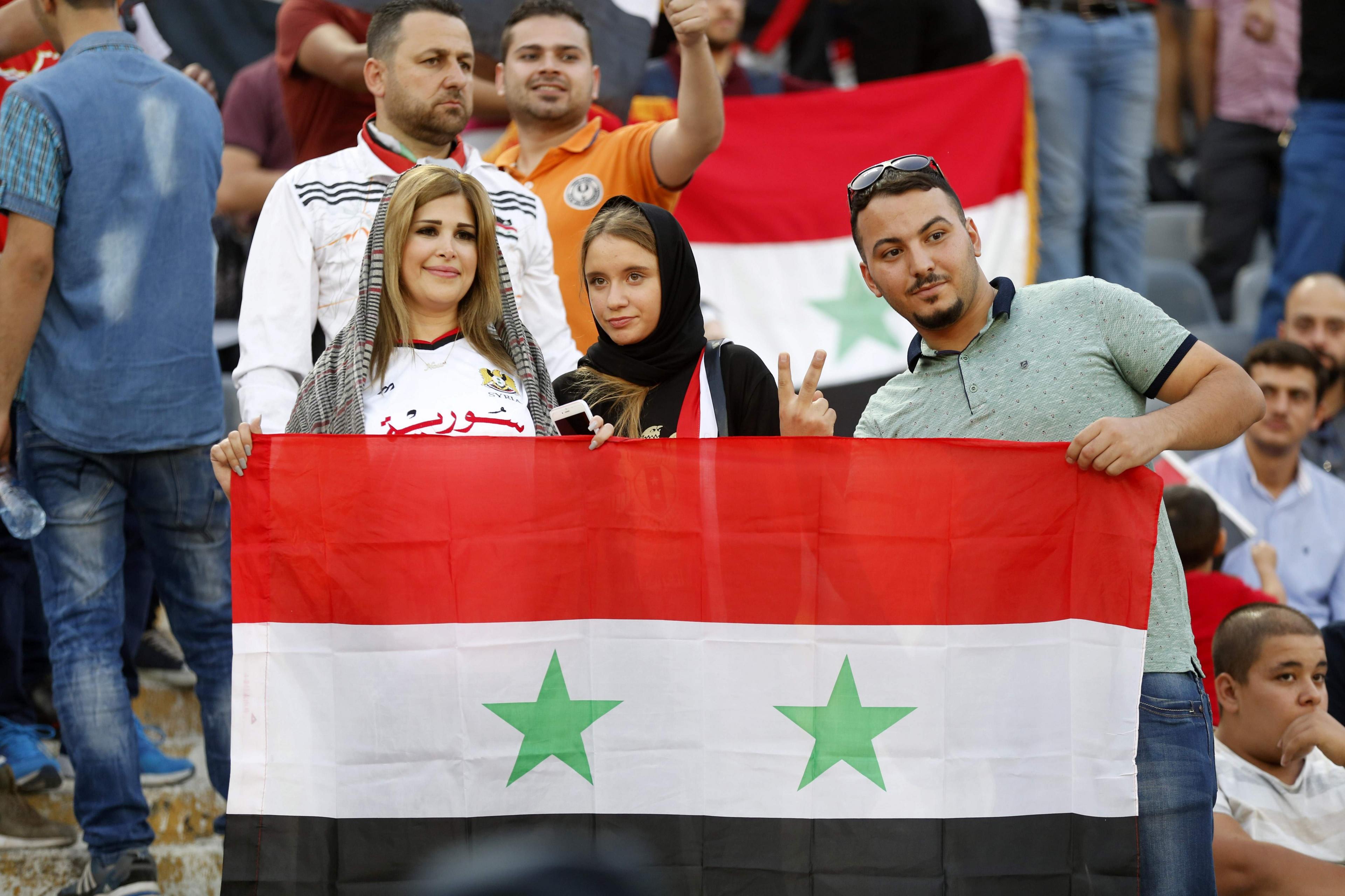 Supporters of Syria cheer for their team during the FIFA World Cup 2018 qualification football match between Iran and Syria at the Azadi Stadium in Tehran on 5 September