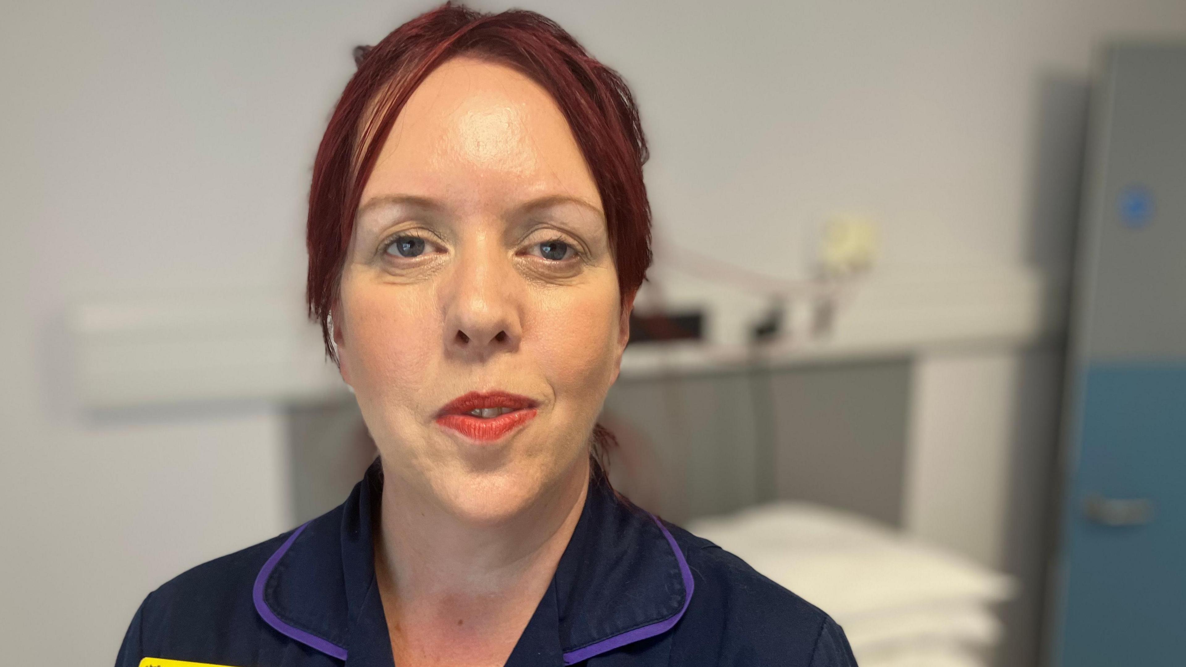 Emma Roberts, a head of nursing from Leicester's NHS hospitals, standing in one of the  ground floor patient bedrooms at Preston Lodge. She is wearing her NHS dark blue uniform.  