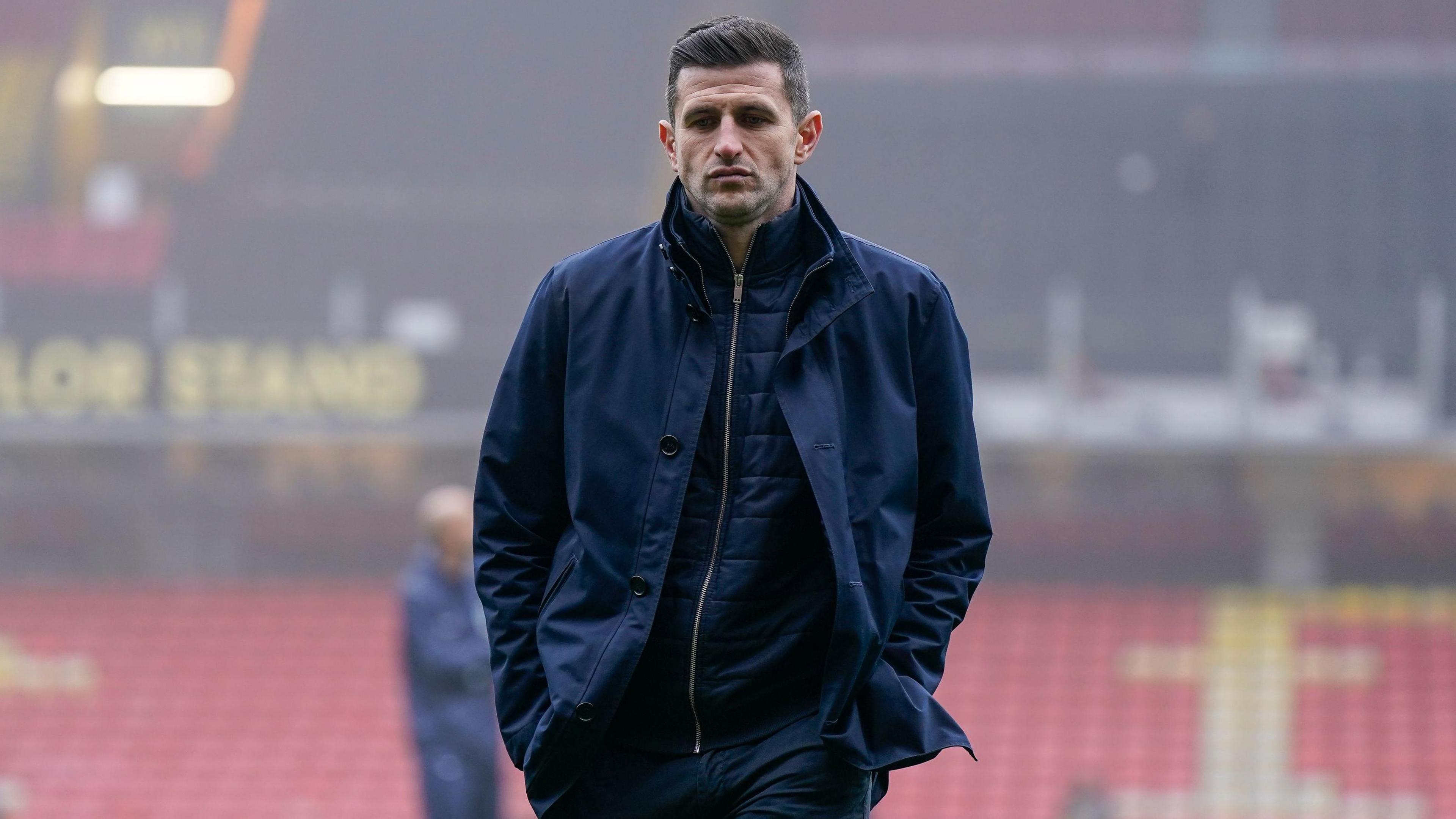 Portsmouth boss John Mousinho walks with his hands in his pockets