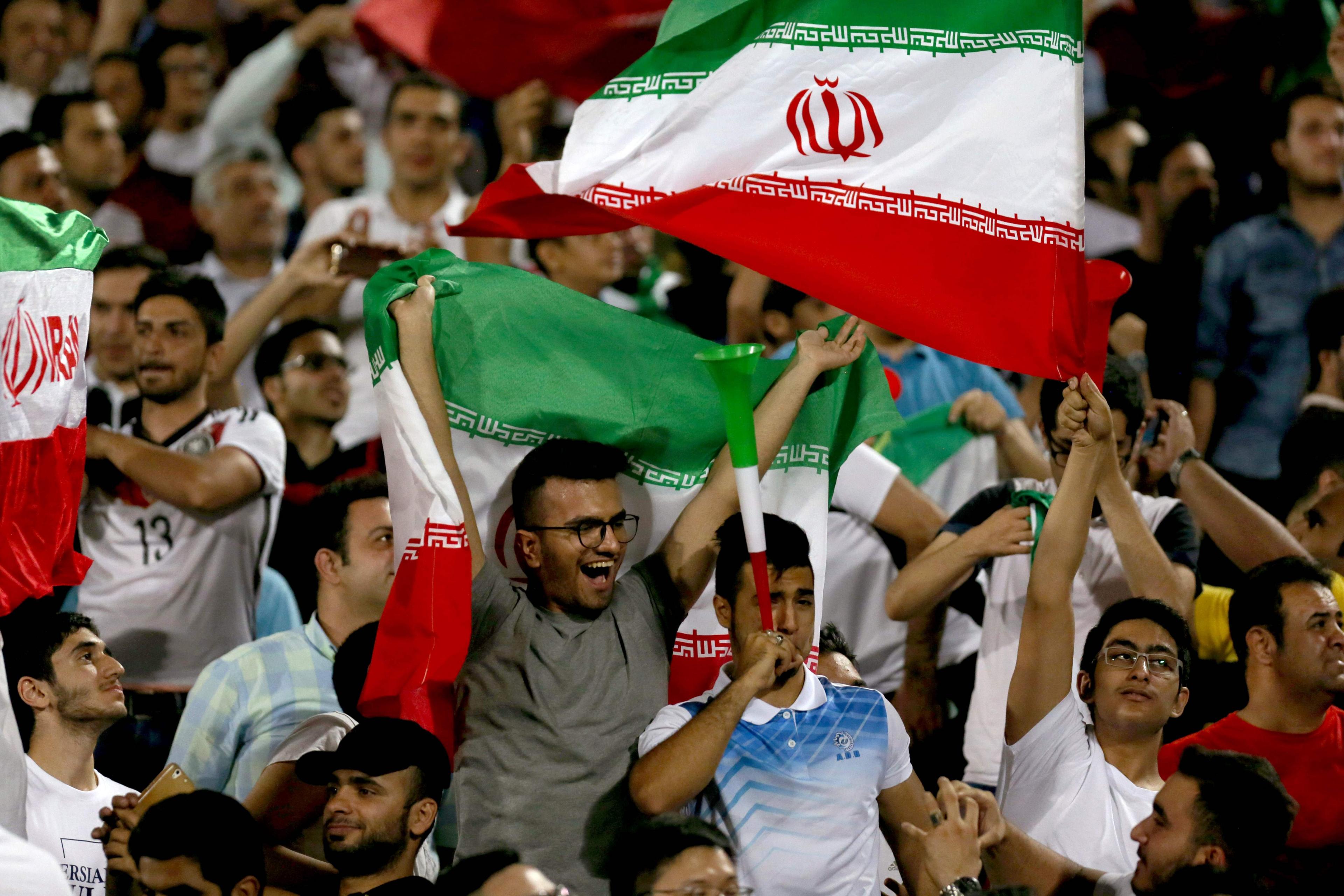 Supporters of Iran cheer for their team during the FIFA World Cup 2018 qualification football between Syria and Iran at the Azadi Stadium in Tehran on 5 September 2017