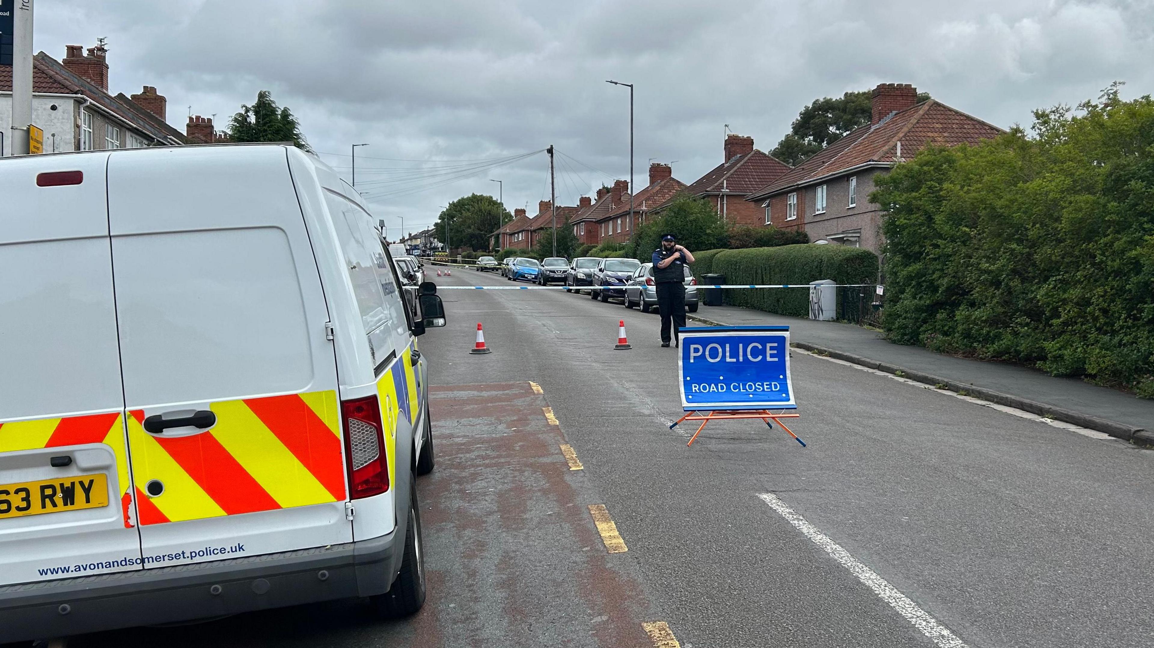 The cordon in Filton Avenue, including a police officer and police van.