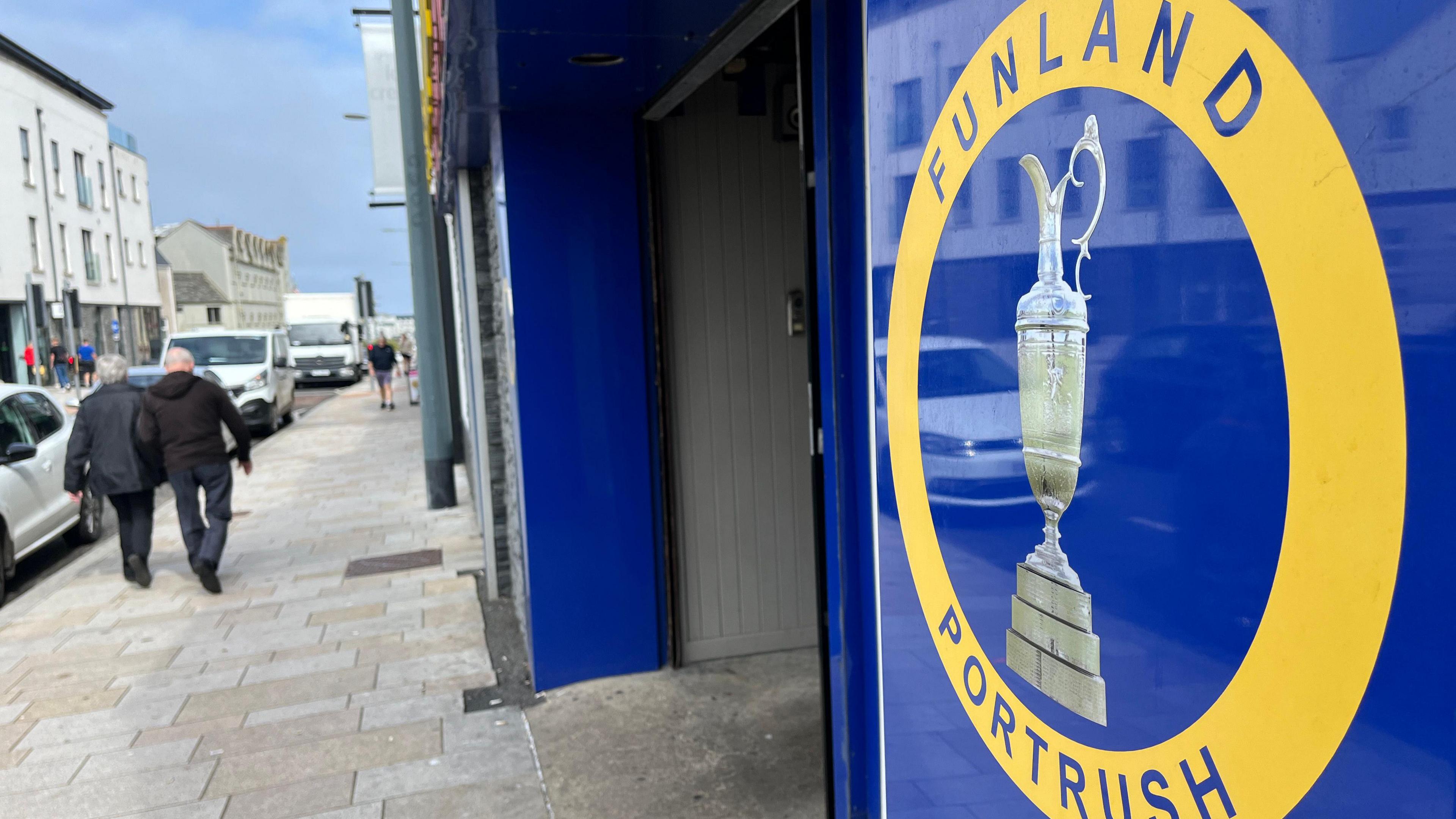 The exterior of amusements Funland in Portrush which has a sign saying 'Funland Portrush' in a blue and yellow circle