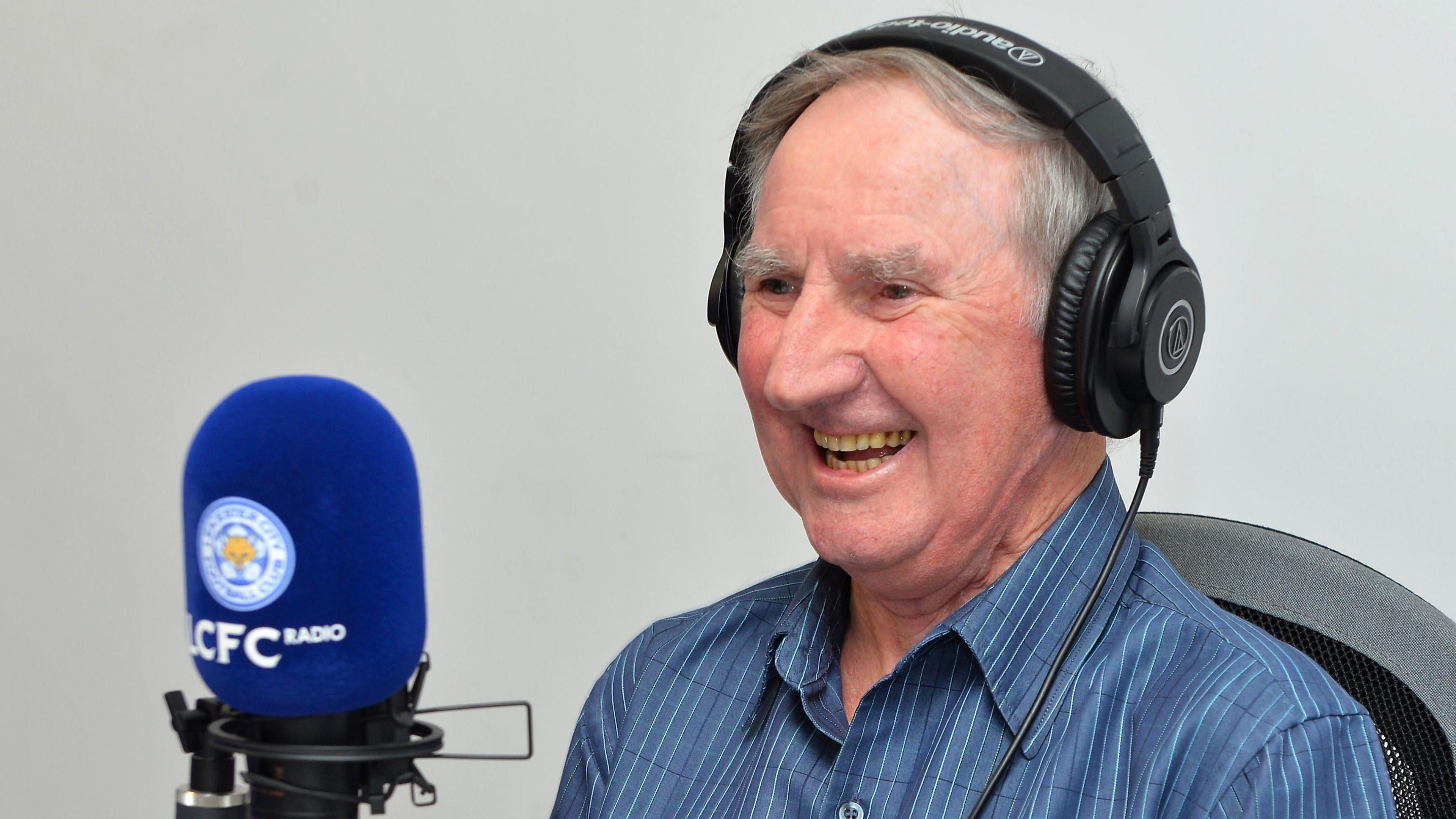 Neville Foulger talks into a microphone with headphones on