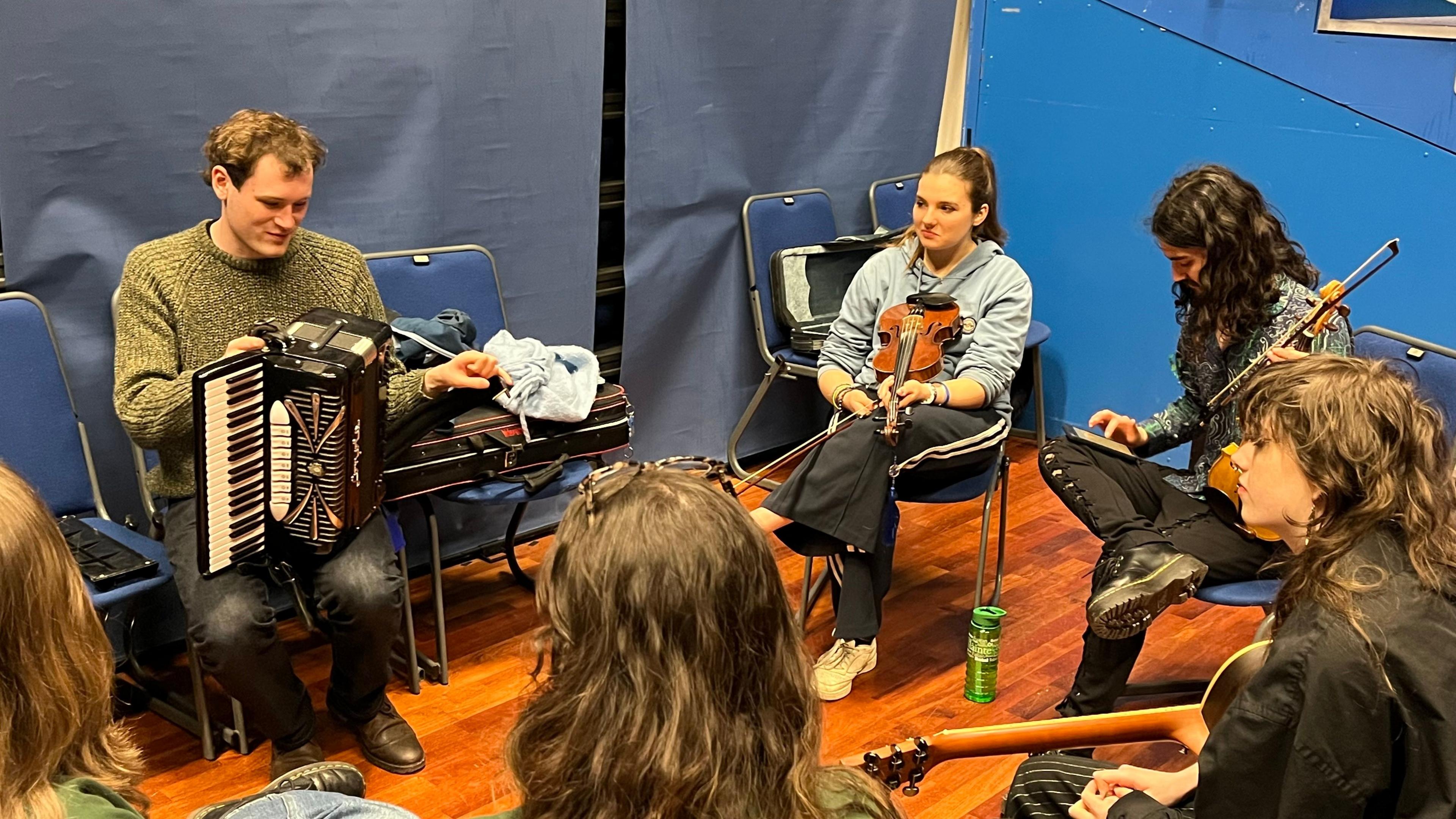 Oileanaich a' taisbeanadh an cuid sgilean ciùil air turas Chomann Nàiseanta nan Oileanch a Leòdhas 