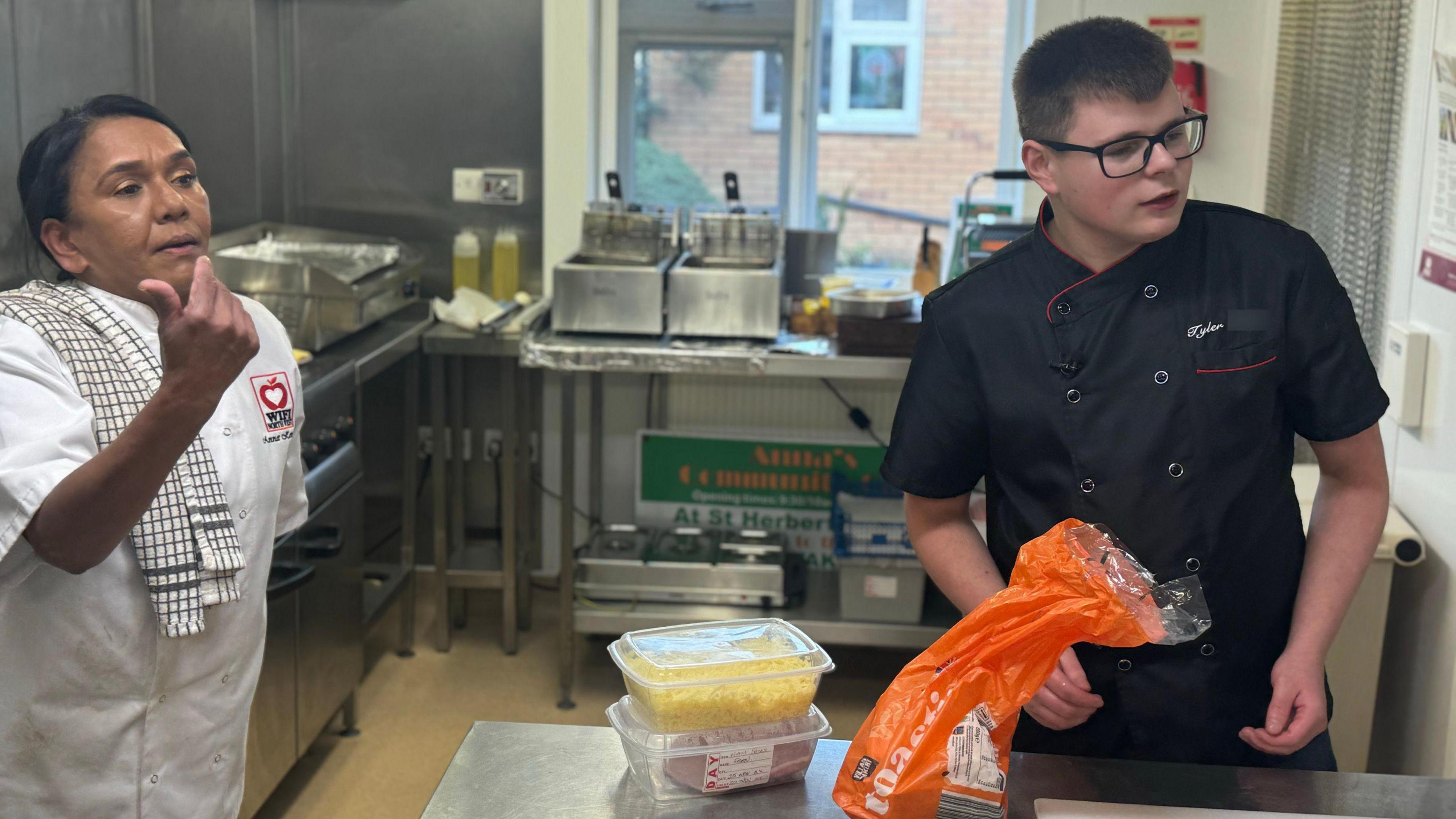 Anna Kennedy and volunteer Tyler working in a kitchen at the cafe