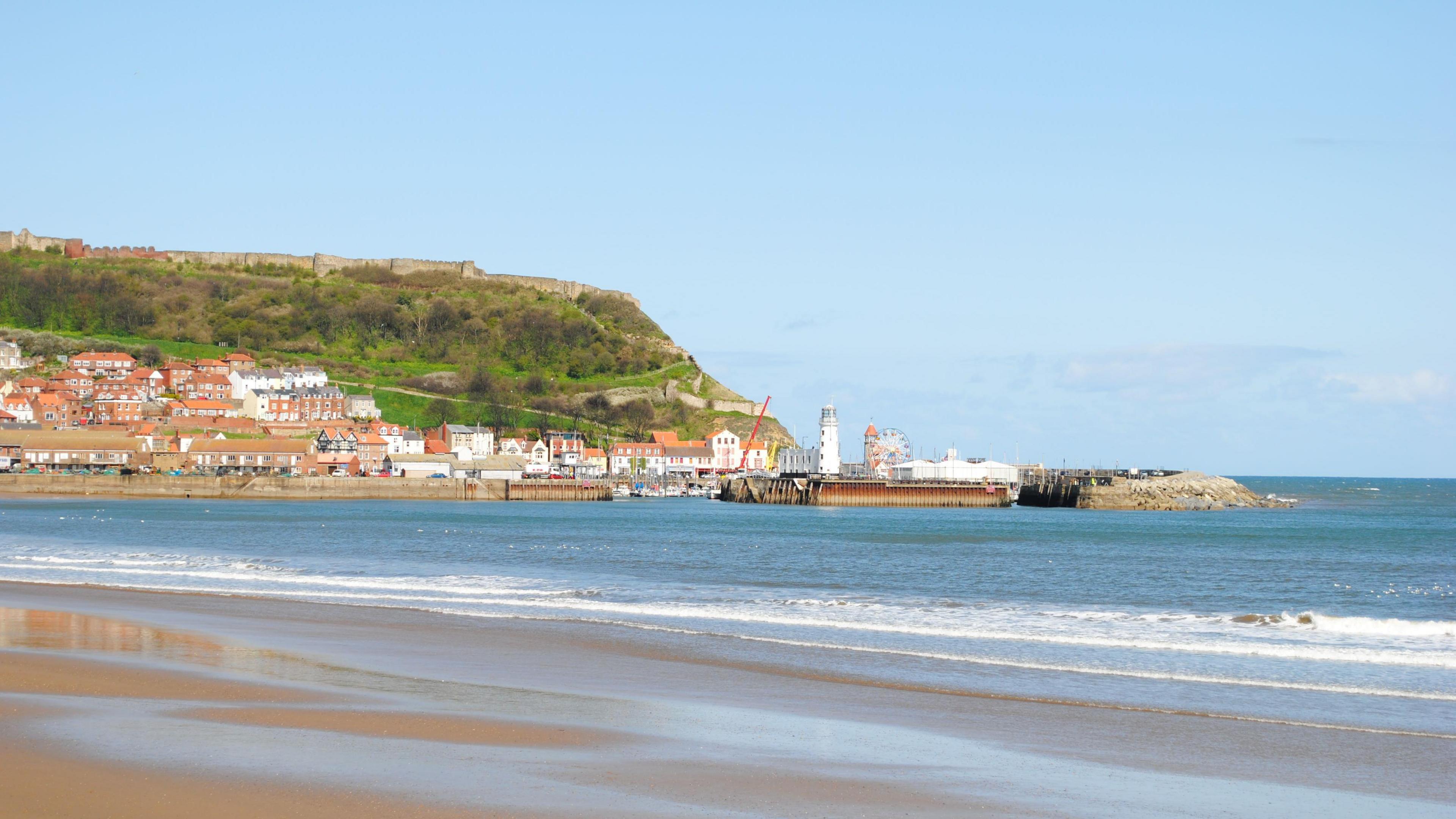 A view of Scarborough beach on a sunny day. A Ferris wheel can be seen in the distance.