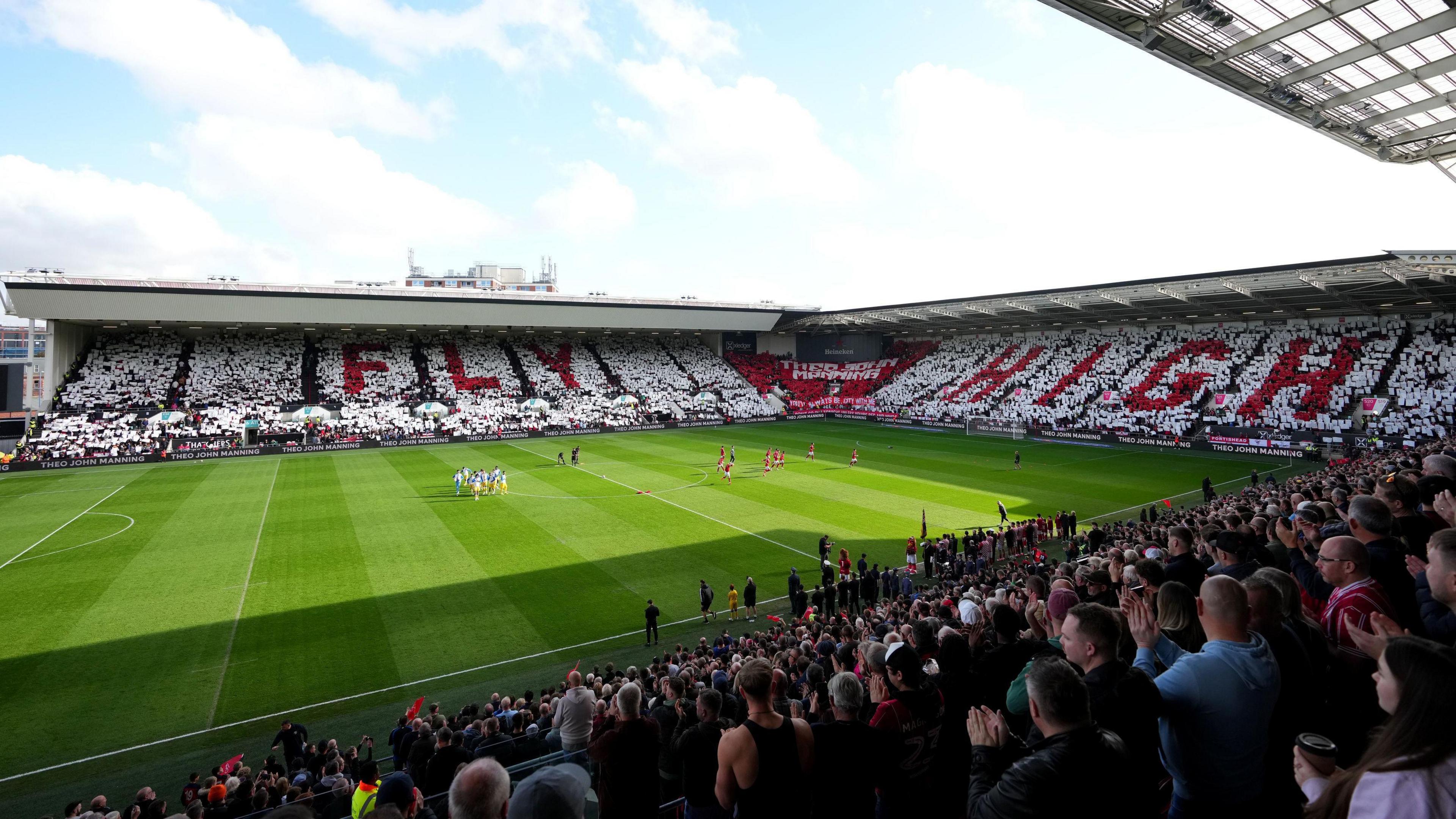 A view of Ashton Gate during a packed football match, with three stands of seating filled by crowds