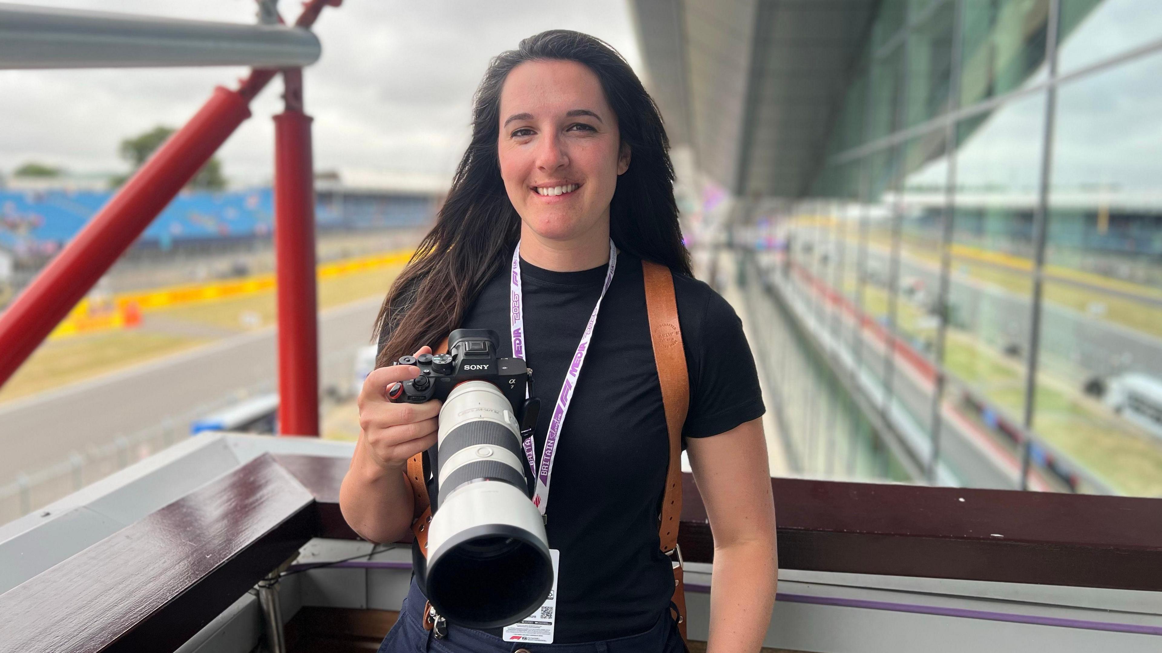 A woman holding a camera with a telephoto lens